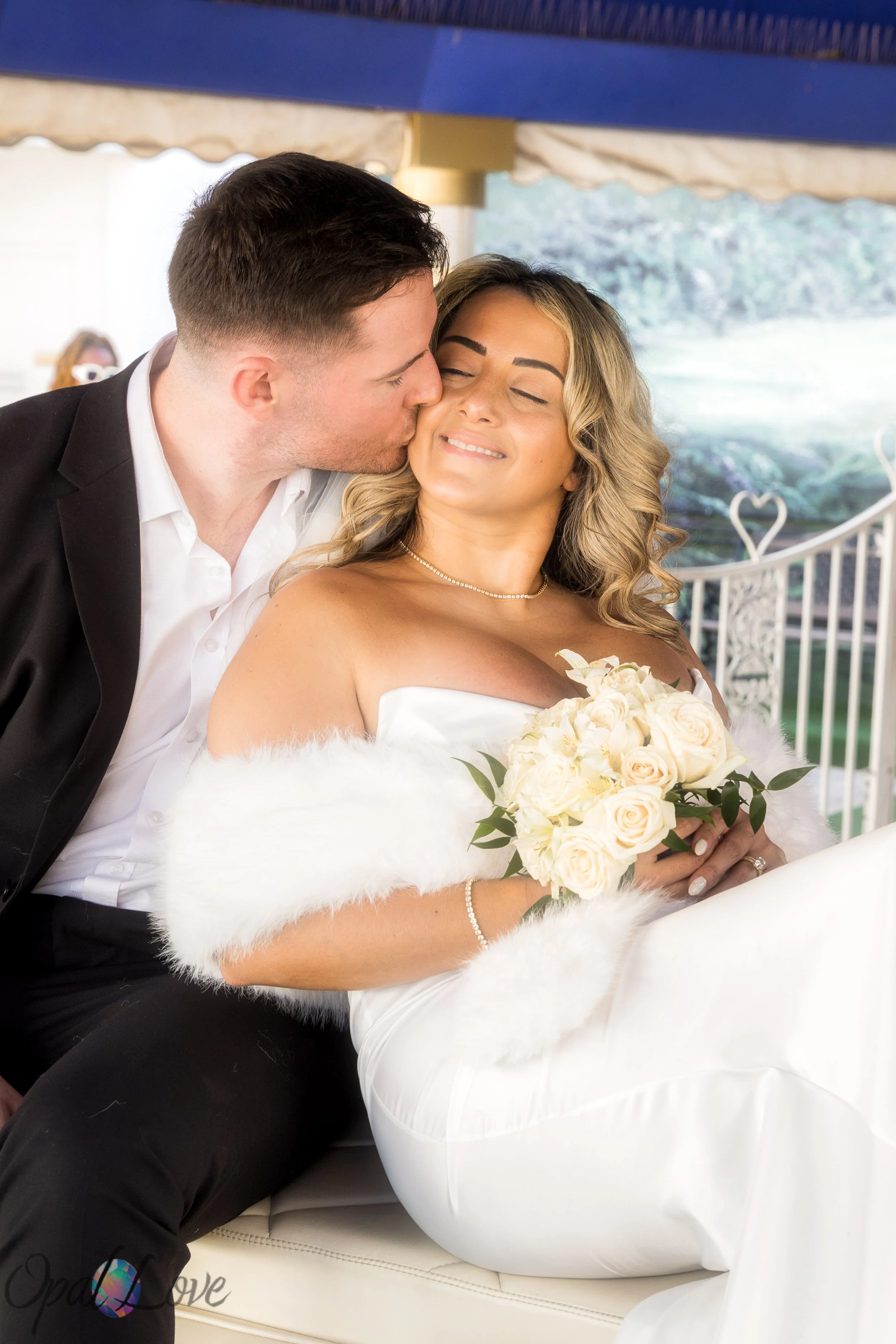 Bride and groom kissing beside the iconic pink Cadillac at Little White Wedding Chapel in Las Vegas.