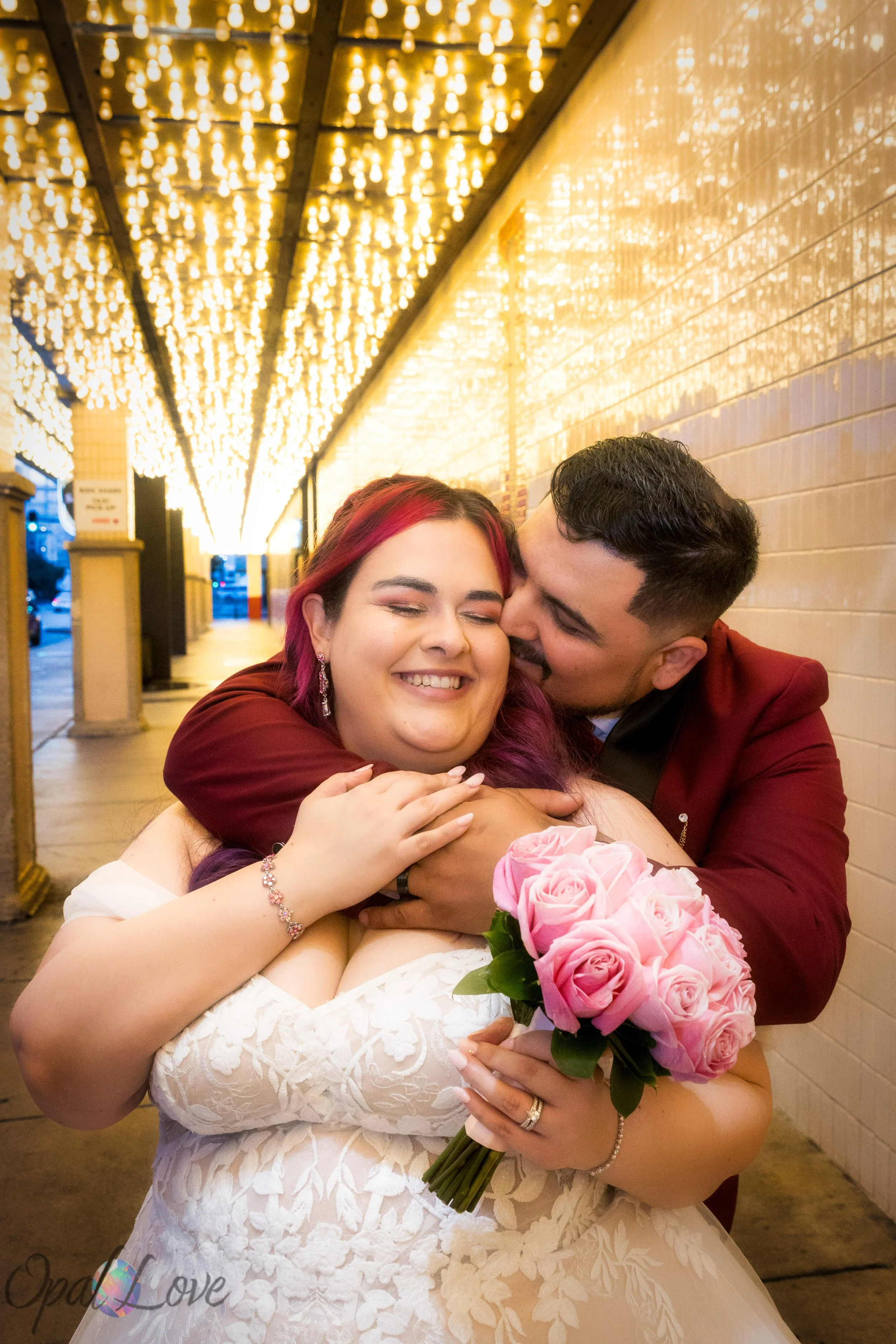 Groom hugging bride under sparkling golden lights on Fremont Street.