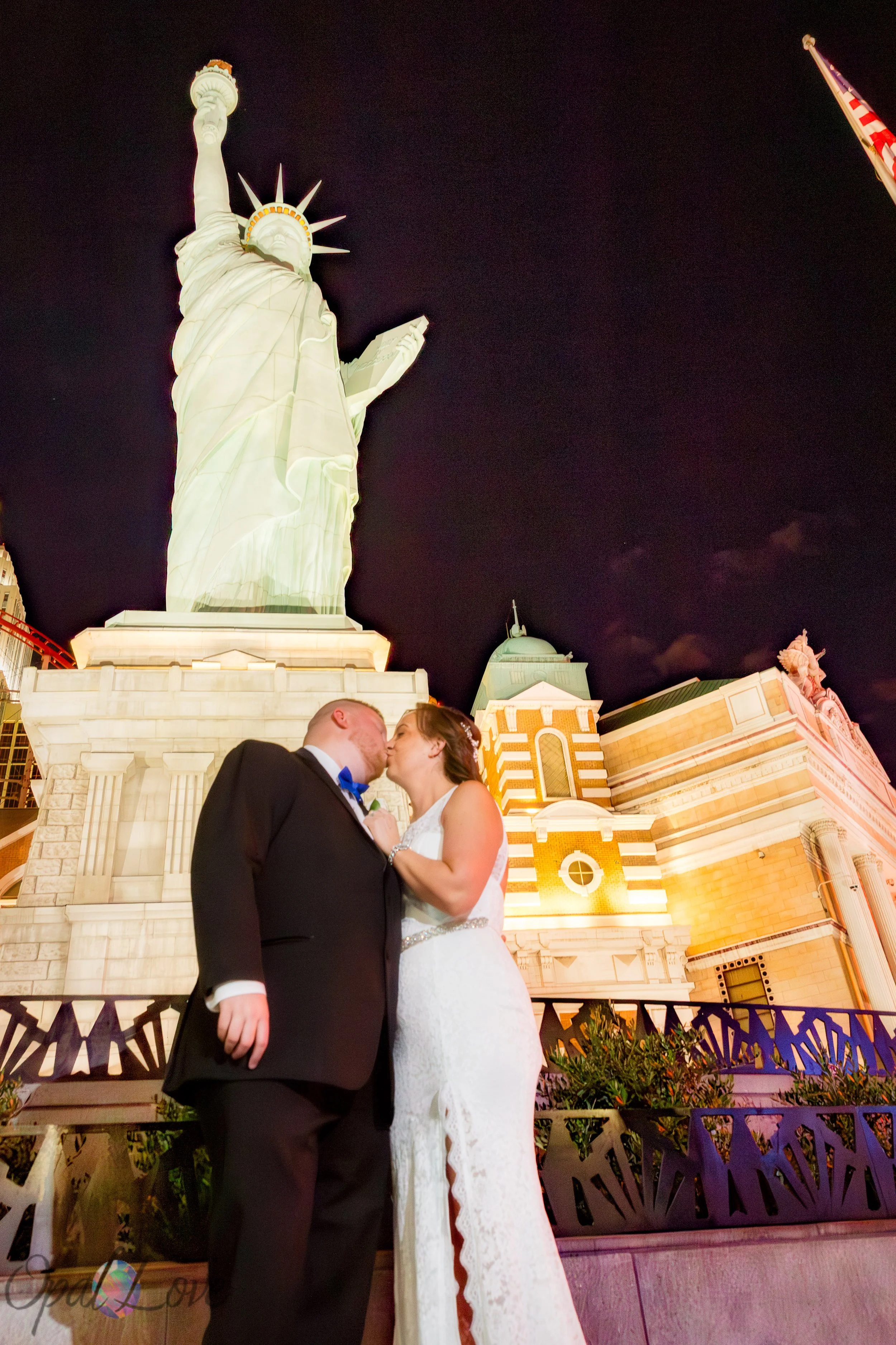 Couple sharing a kiss beneath the Statue of Liberty replica at New York New York in Las Vegas.
