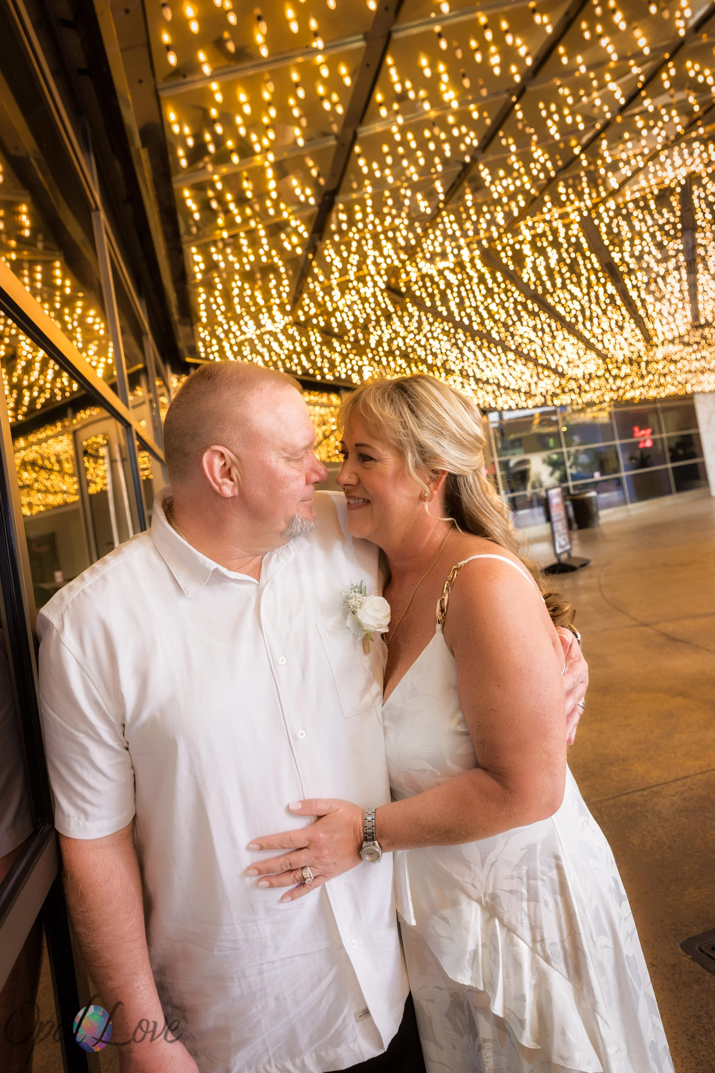 Couple embracing under the glowing Fremont Street canopy lights during their Las Vegas elopement photo tour.