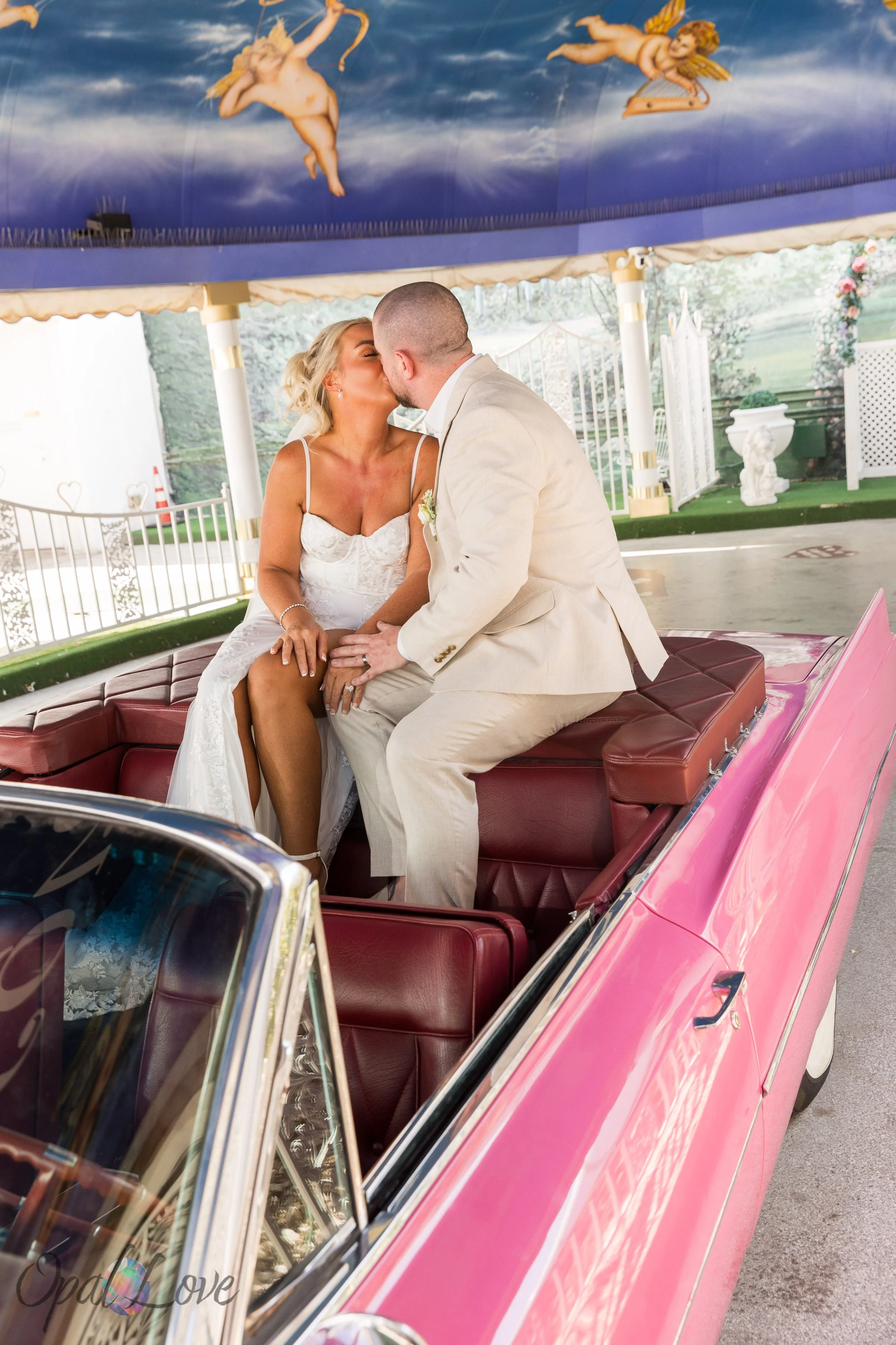 Bride and groom kissing inside the pink Cadillac at the Little White Chapel in Las Vegas.