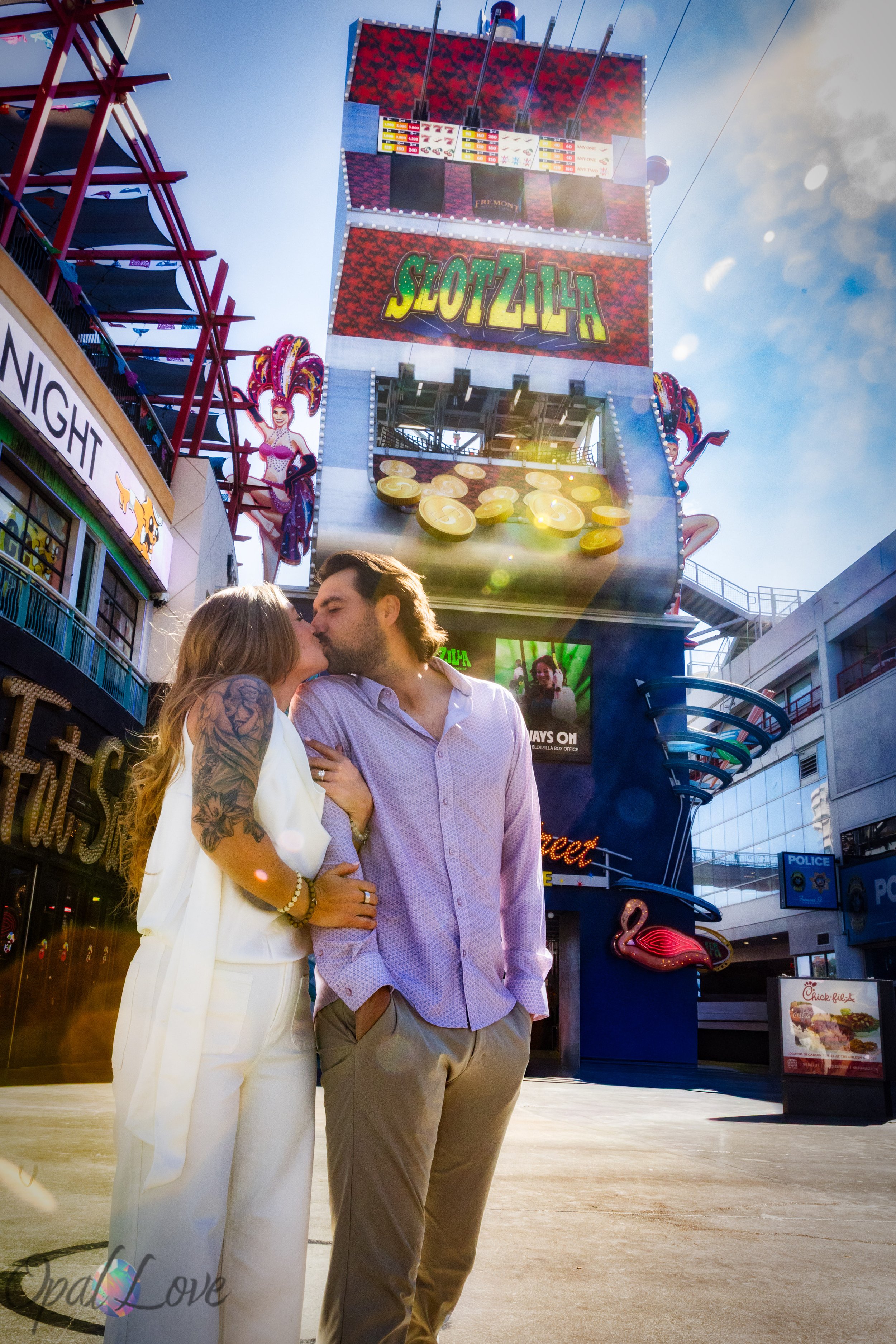 Couple kissing in front of the SlotZilla zipline tower on Fremont Street during their Las Vegas engagement photo tour.