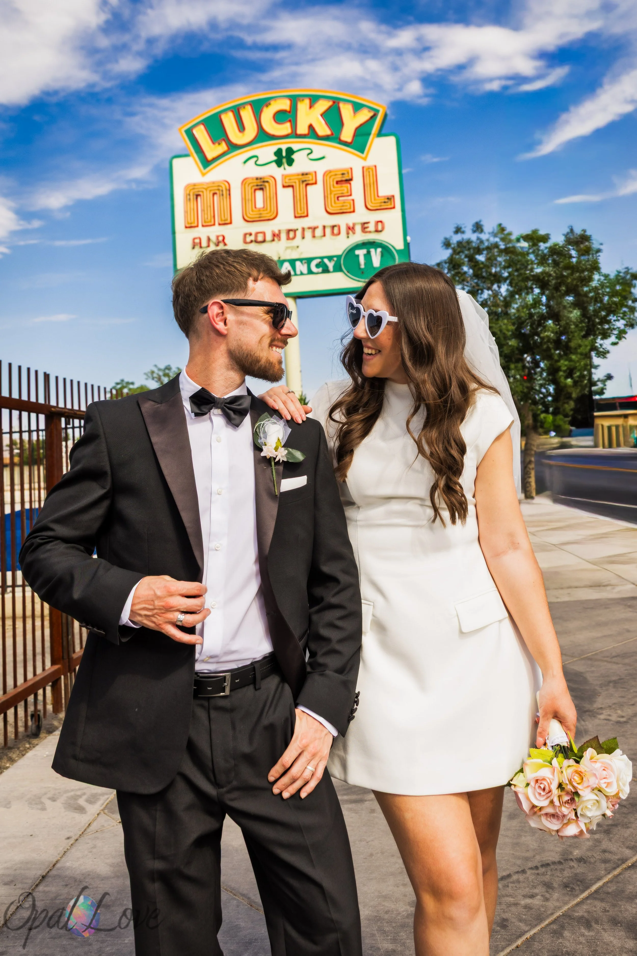 Couple walking beneath Lucky Motel sign during Las Vegas vow renewal photo session