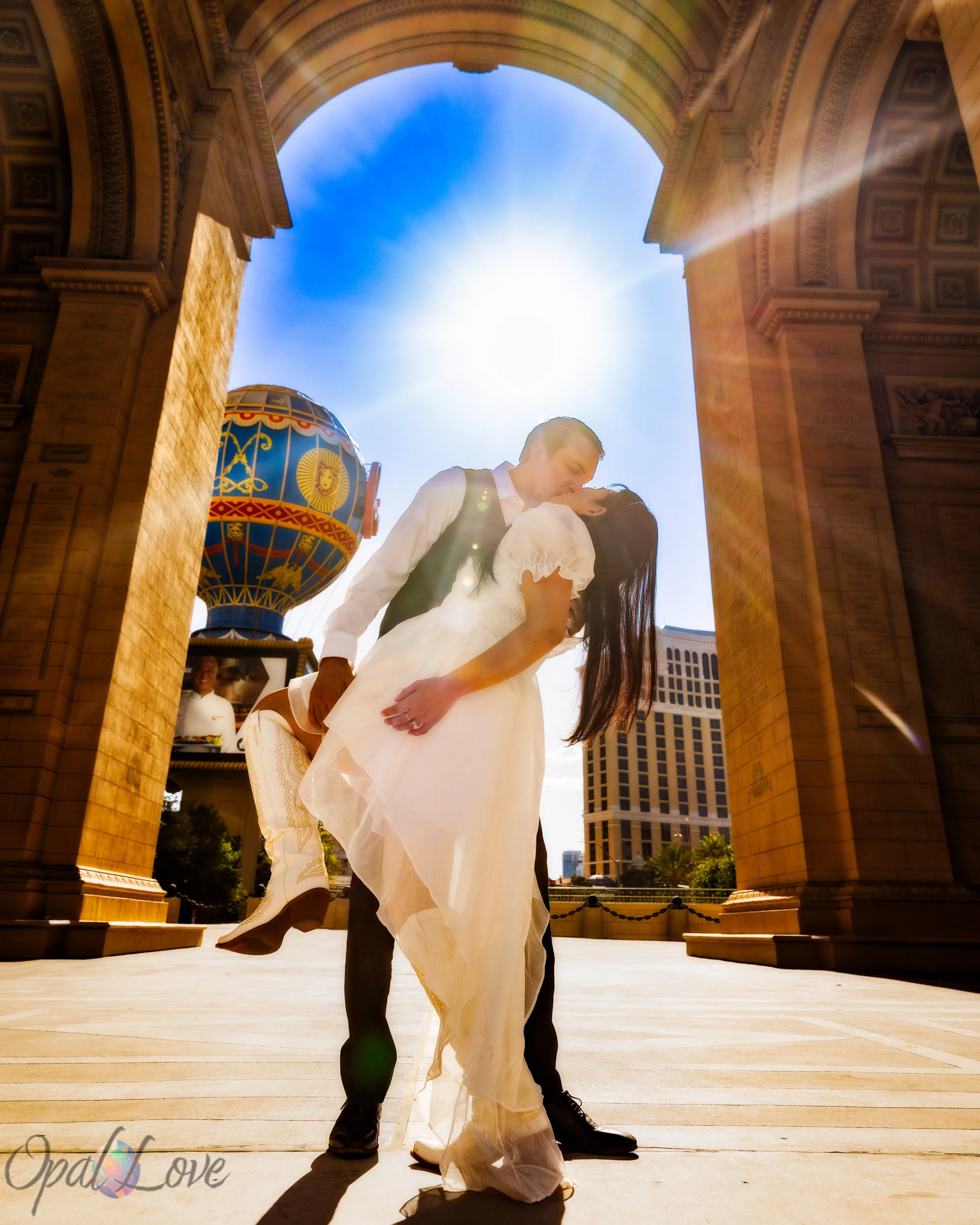 Wedding couple kissing beneath the Arc de Triomphe at Paris Las Vegas
