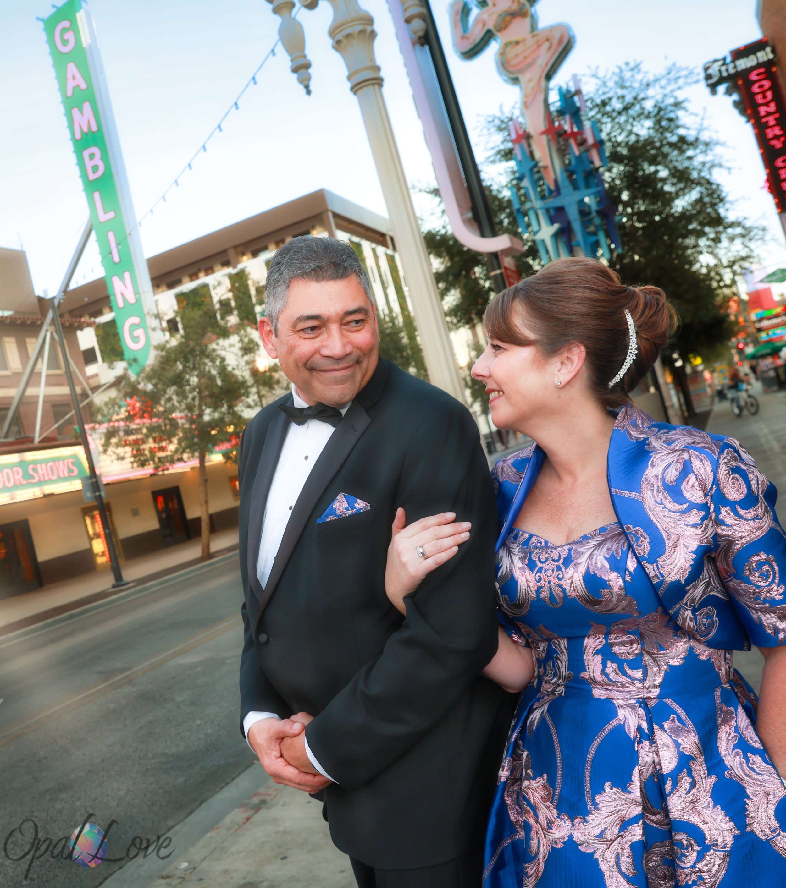 Couple walking together through the vintage neon signs of Fremont East.