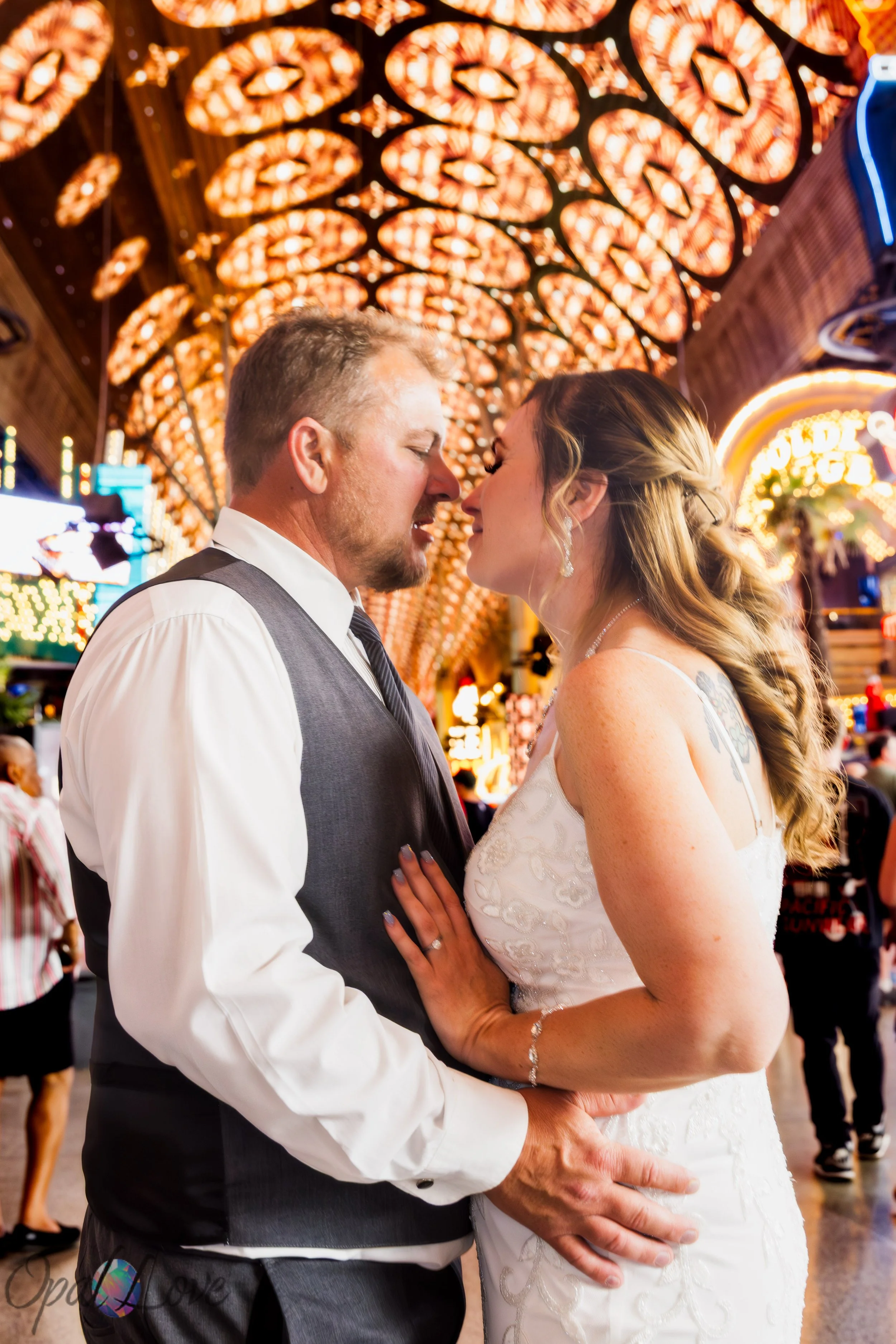 Newly married couple sharing a kiss beneath the Fremont Street Experience canopy in downtown Las Vegas.