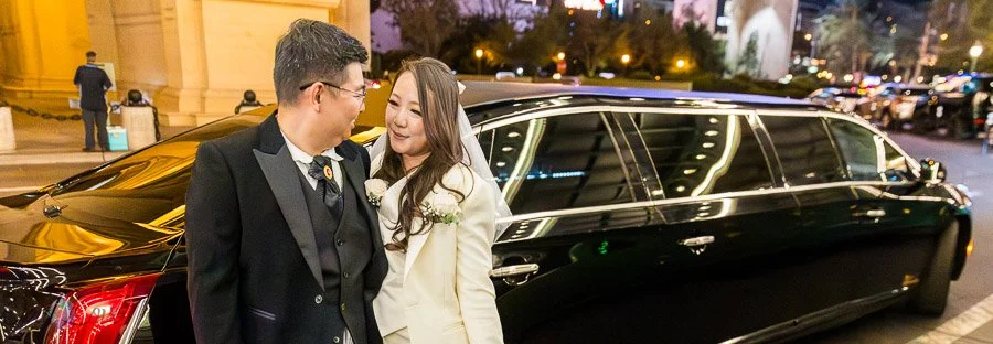 Newlywed couple standing beside their limousine at Paris Las Vegas.