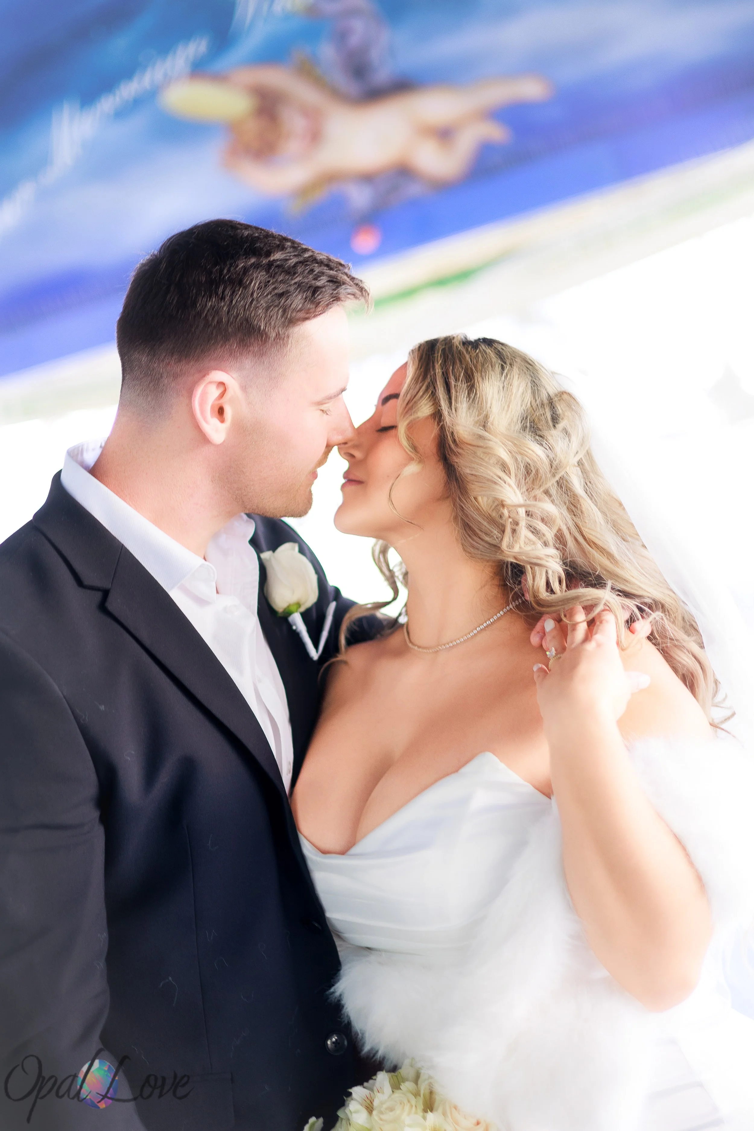Newlyweds leaning close together beneath a ceiling painted with cherubs.