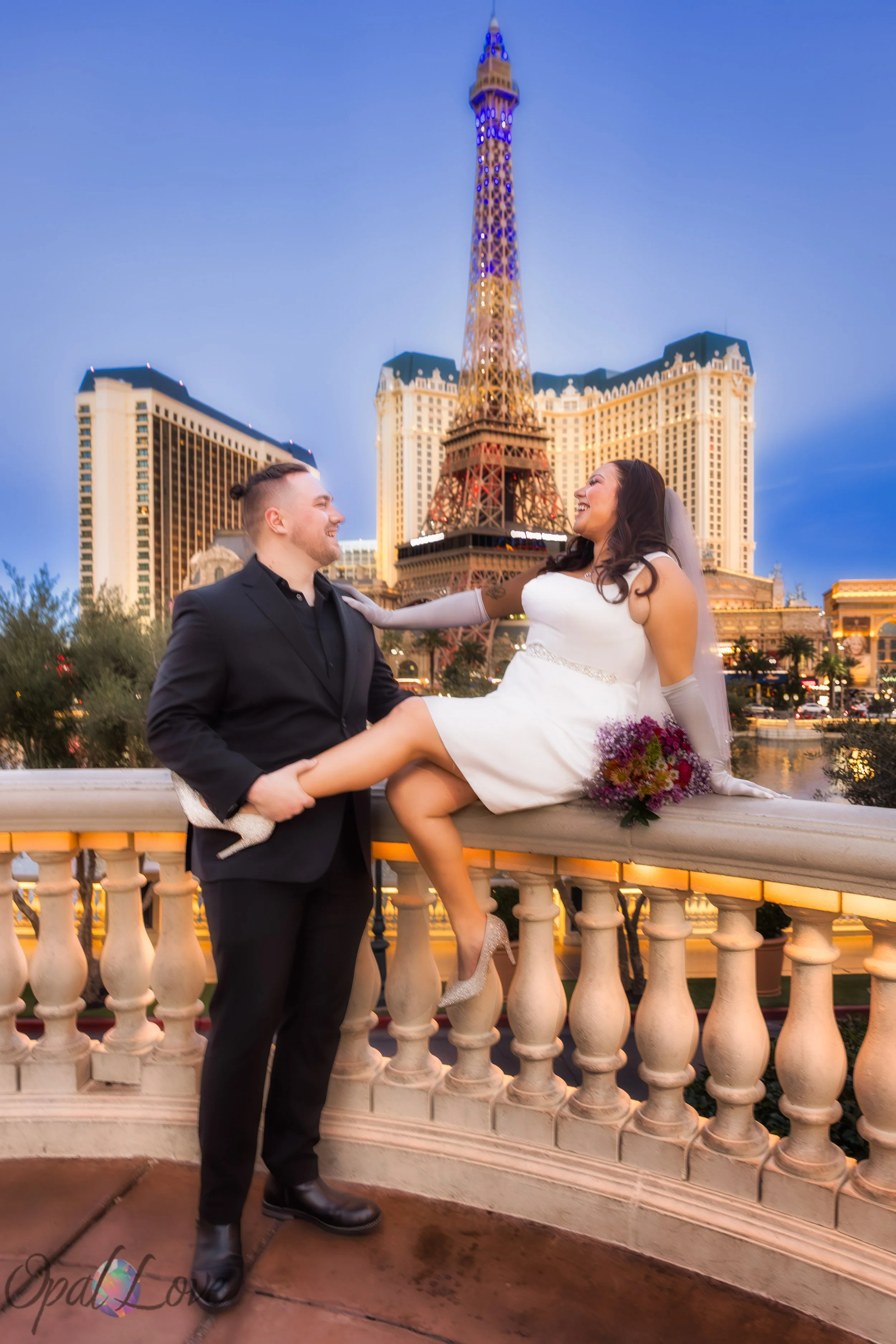 Couple laughing on balcony at Bellagio with the Eiffel Tower in the background