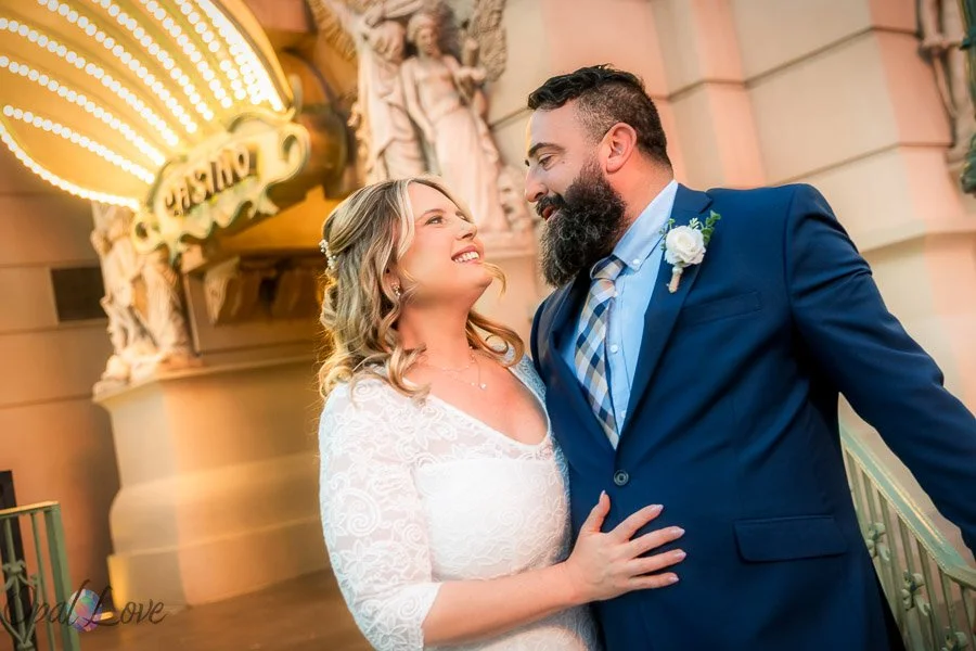 Newlywed couple smiling at each other outside a Las Vegas wedding venue.