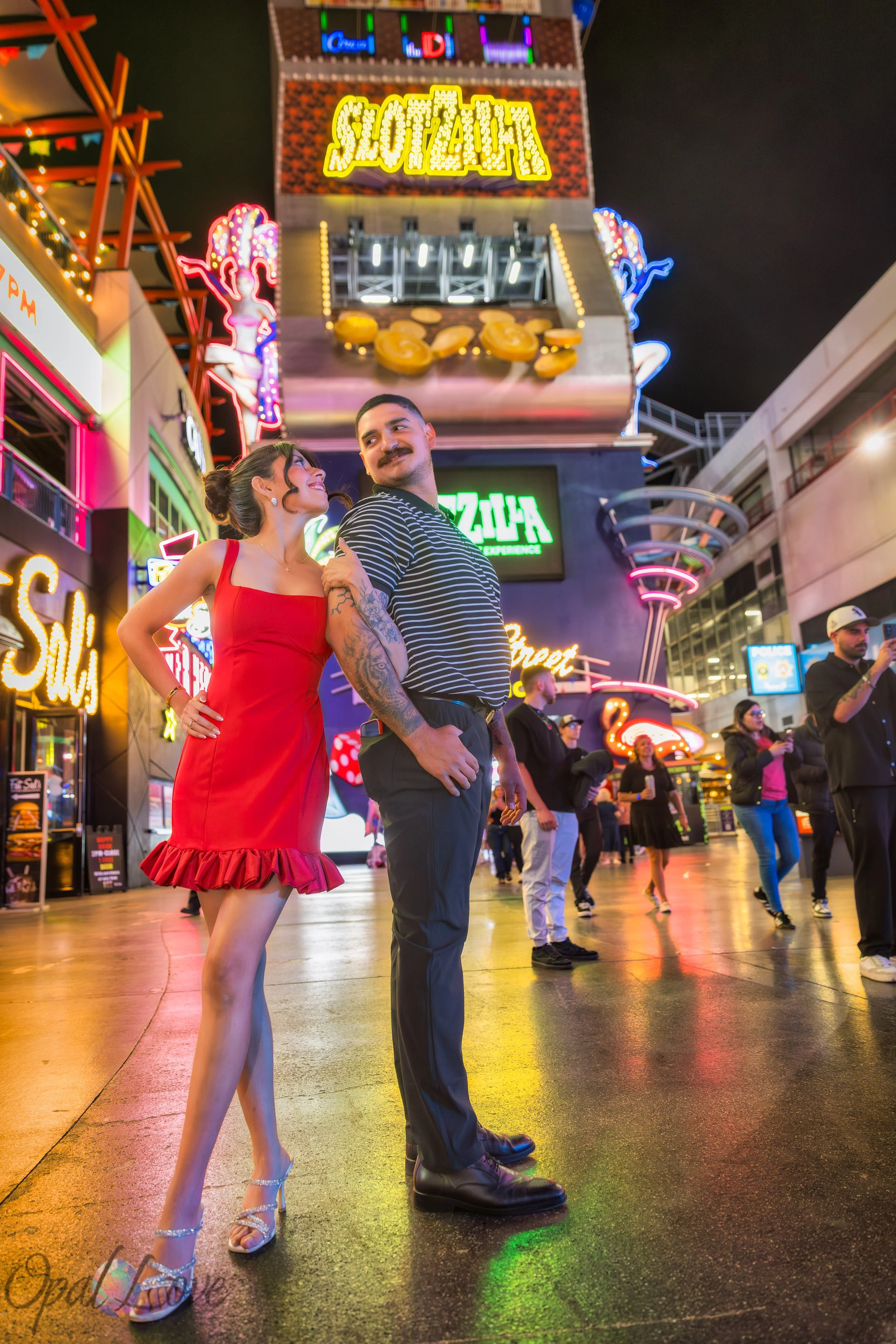 Couple posing under neon lights on Fremont Street in Downtown Las Vegas at night