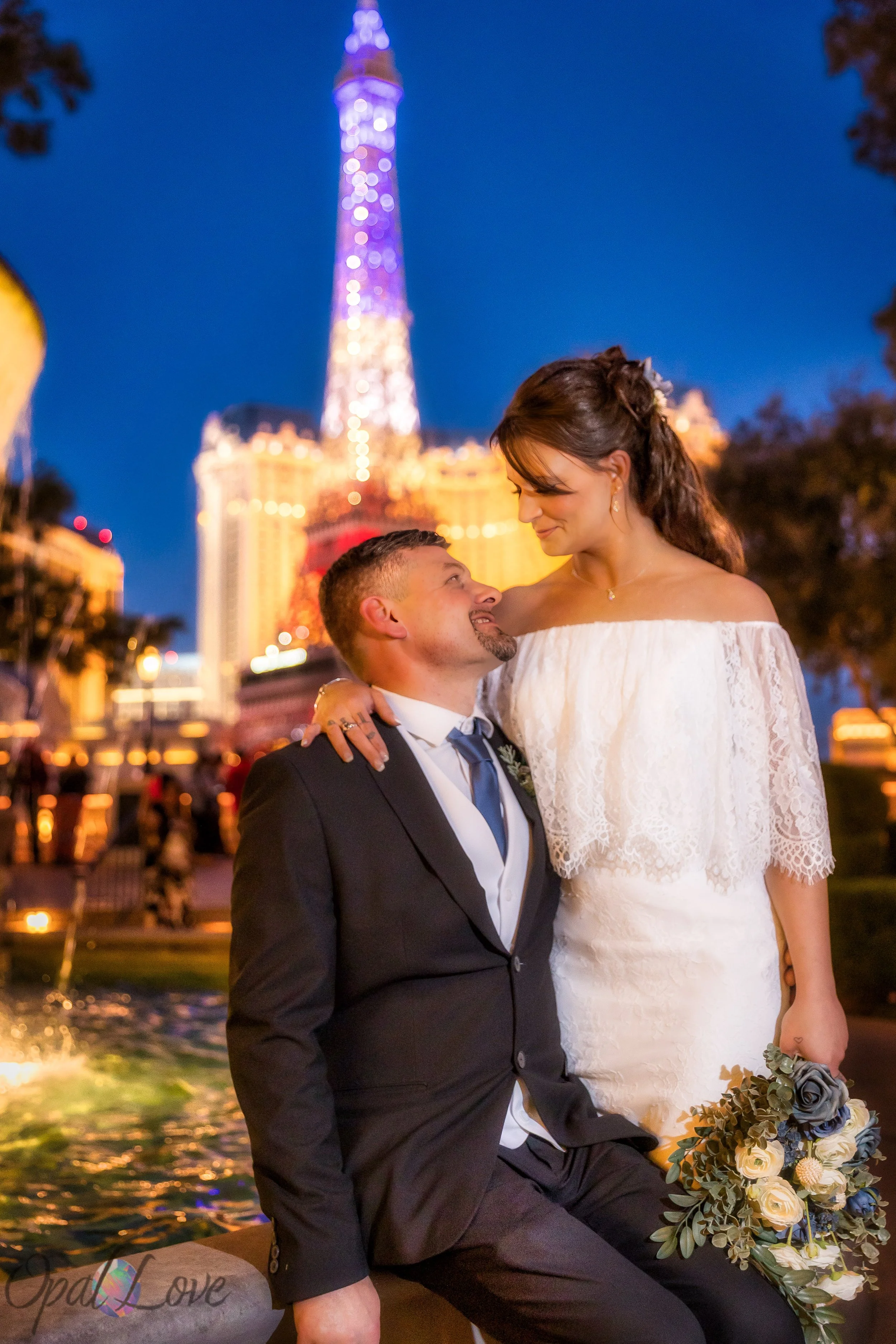 Bride and groom looking into each other’s eyes with the Eiffel Tower at Paris Las Vegas behind them.