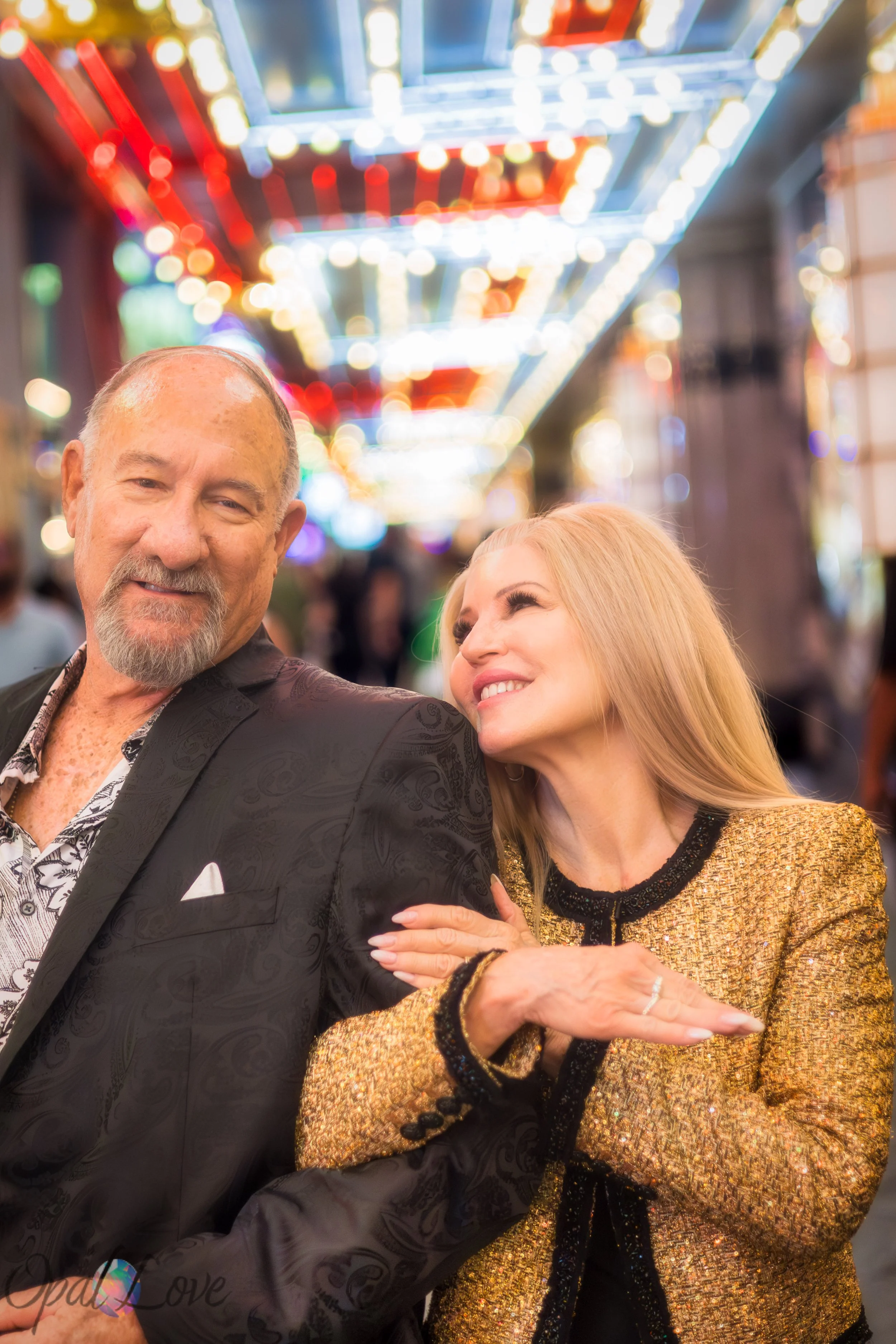 Woman leaning on her partner’s shoulder under the glowing Fremont Street ceiling lights.