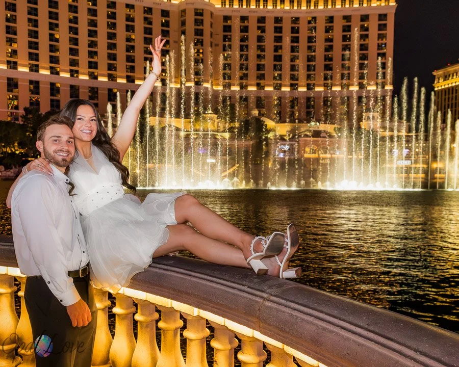 Couple celebrating together in front of the Bellagio fountains at night in Las Vegas.