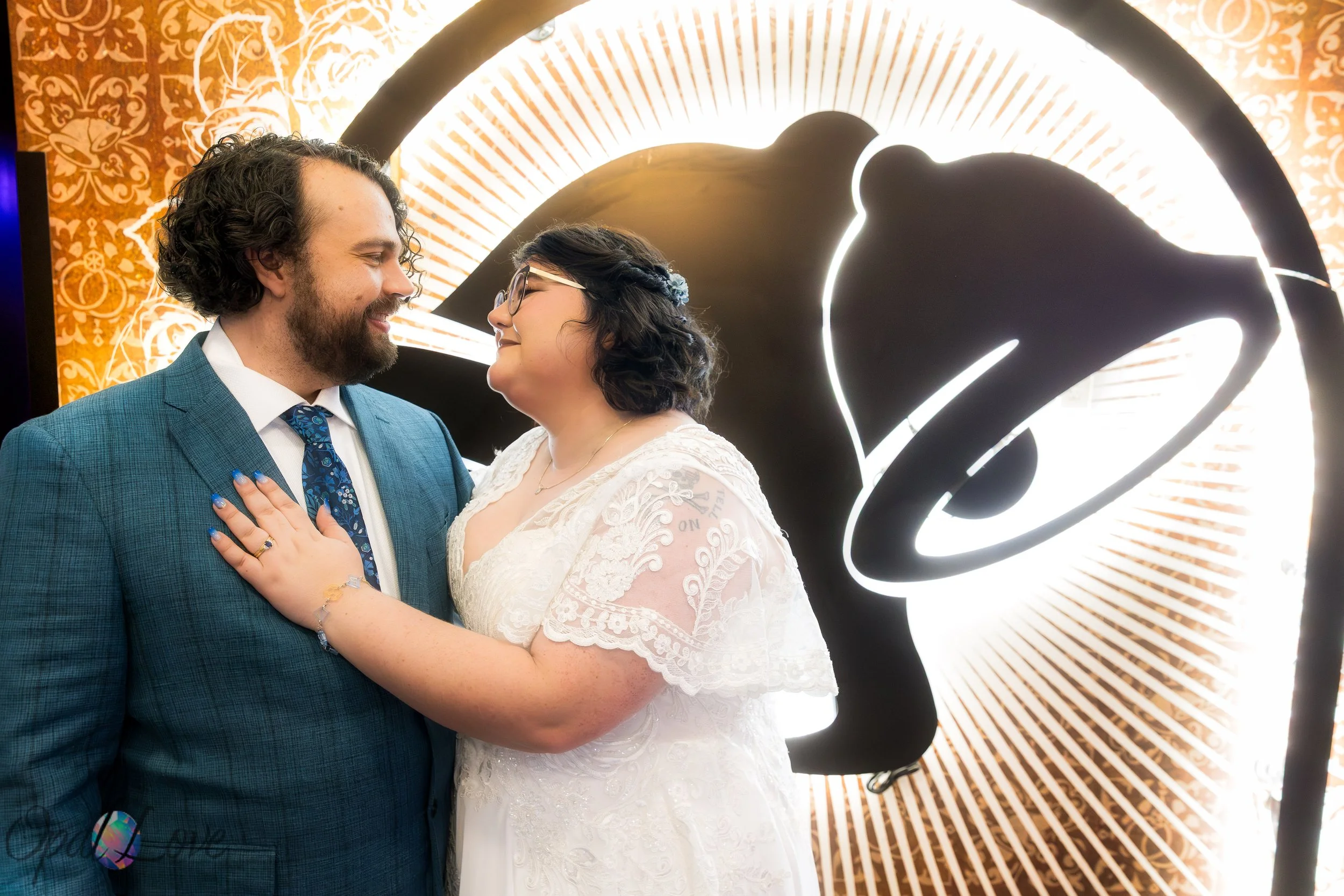 Couple smiling and holding each other in front of the Taco Bell Cantina backdrop.