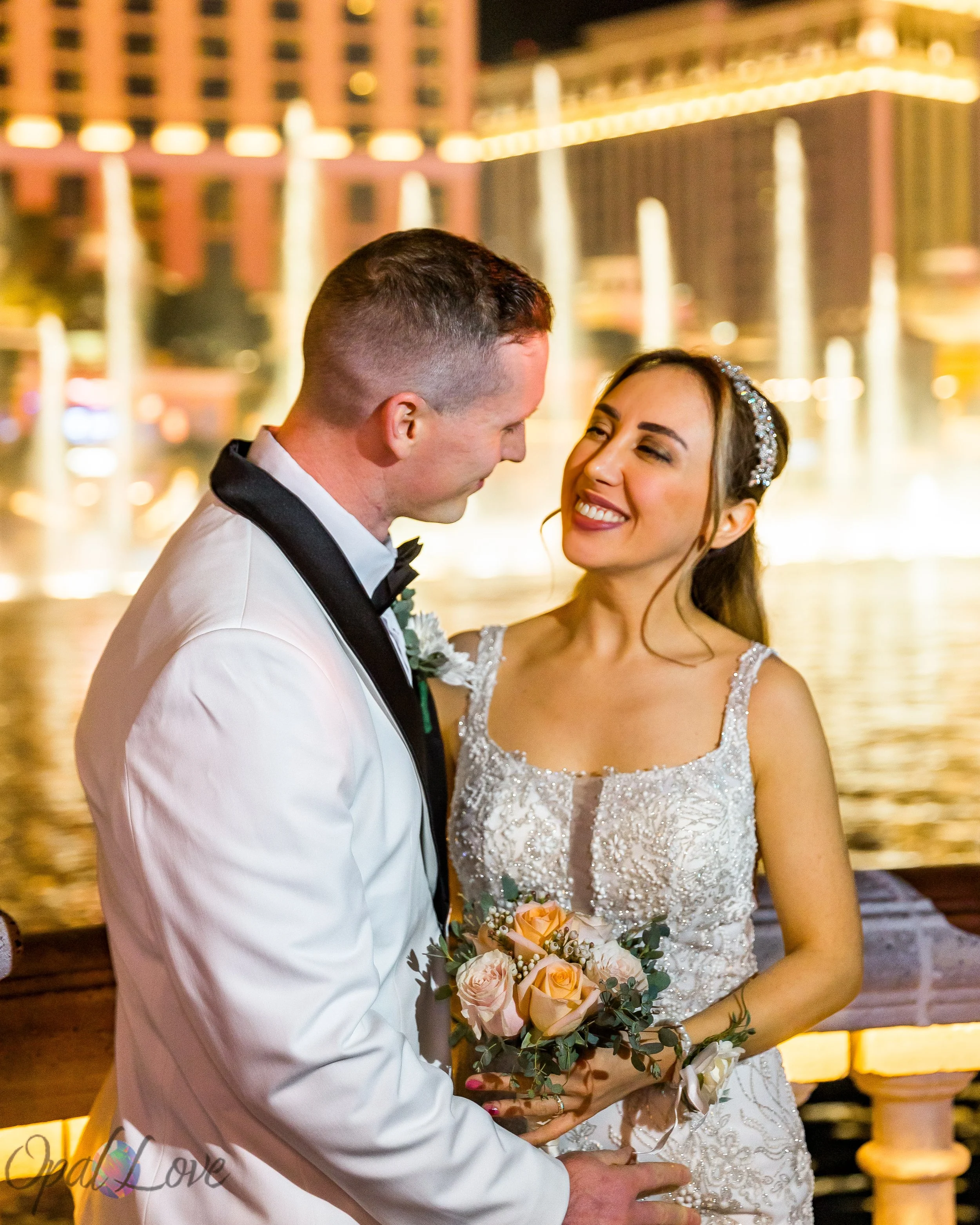 Couple smiling at each other in front of the Bellagio fountains