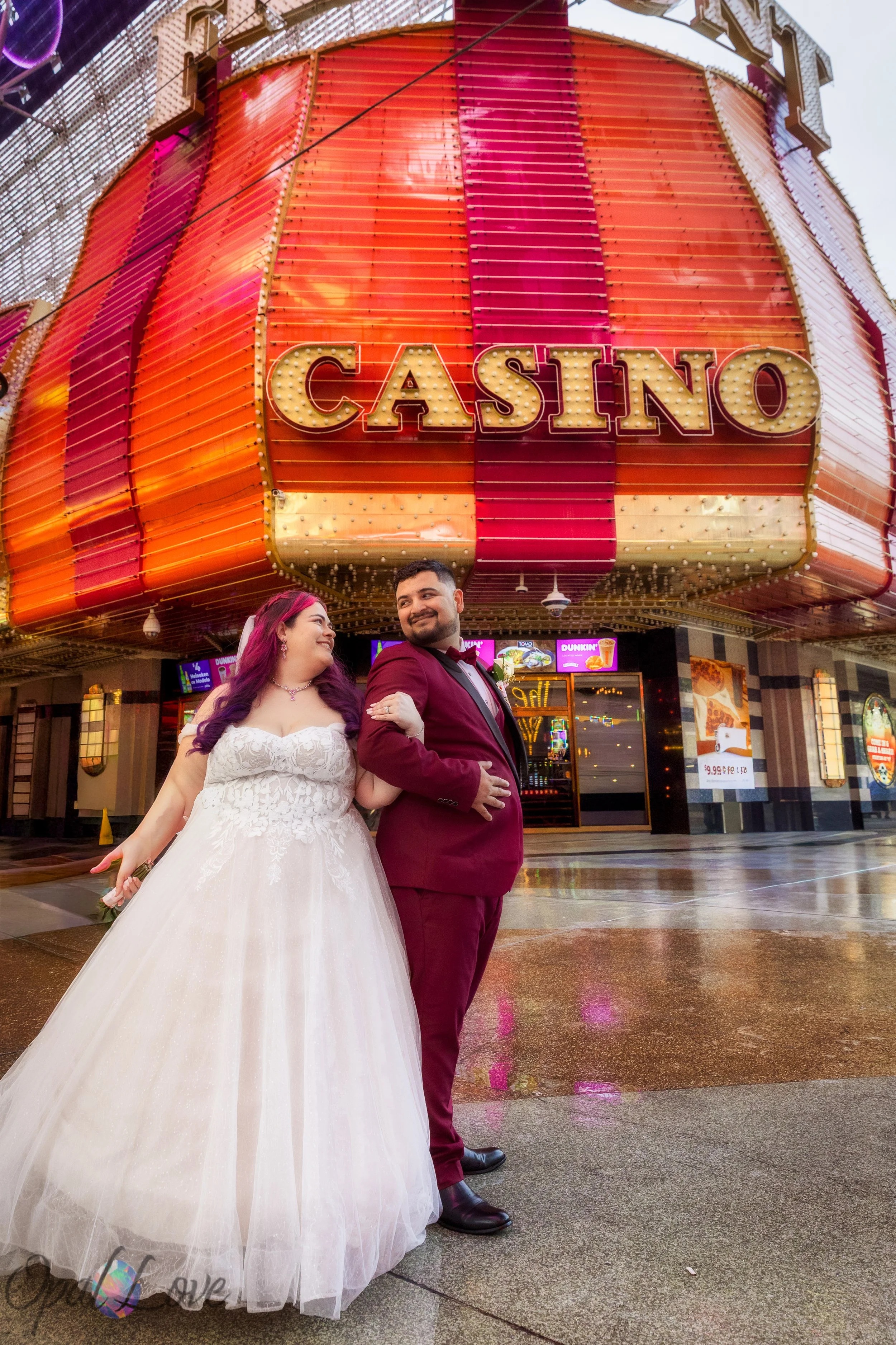 Newly married couple posing under the Fremont Street Experience canopy in downtown Las Vegas