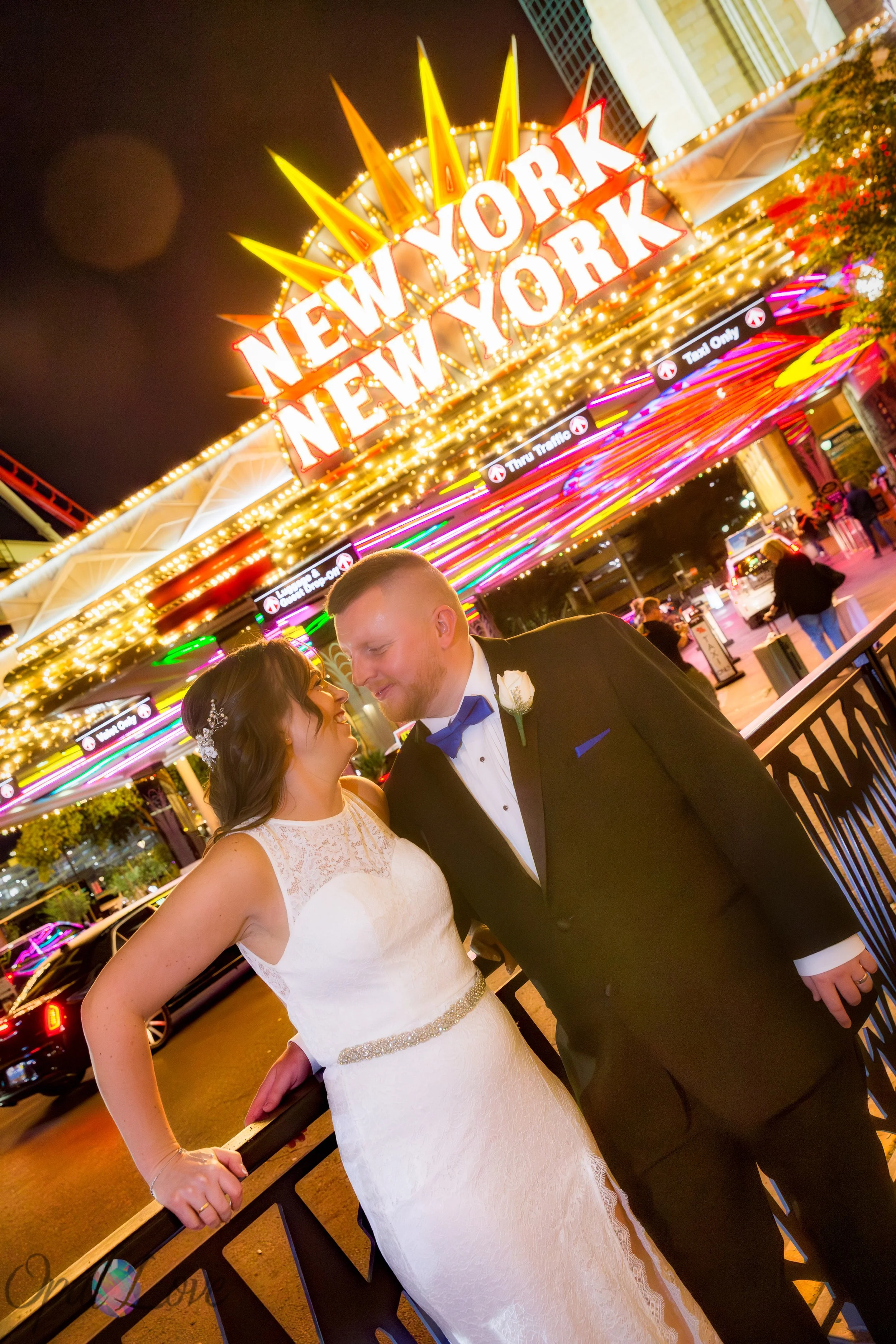 Bride and groom laughing together under the glowing New York New York marquee.