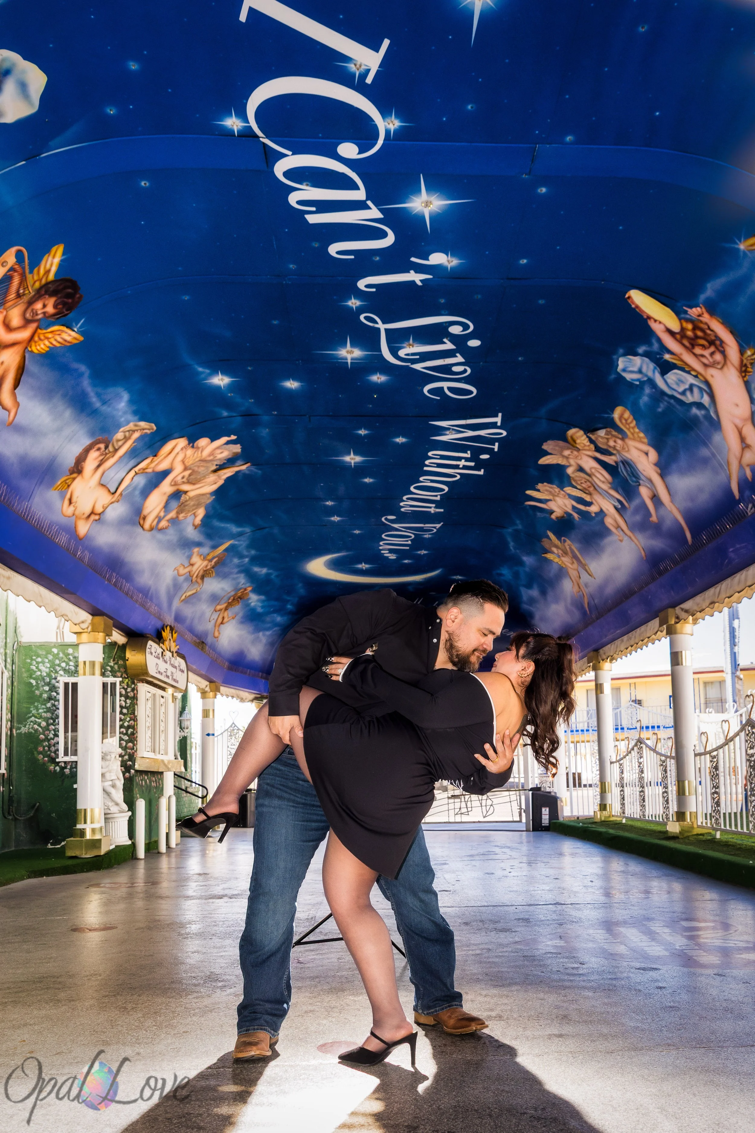 Groom dipping bride beneath the star and cherub mural at A Little White Wedding Chapel.