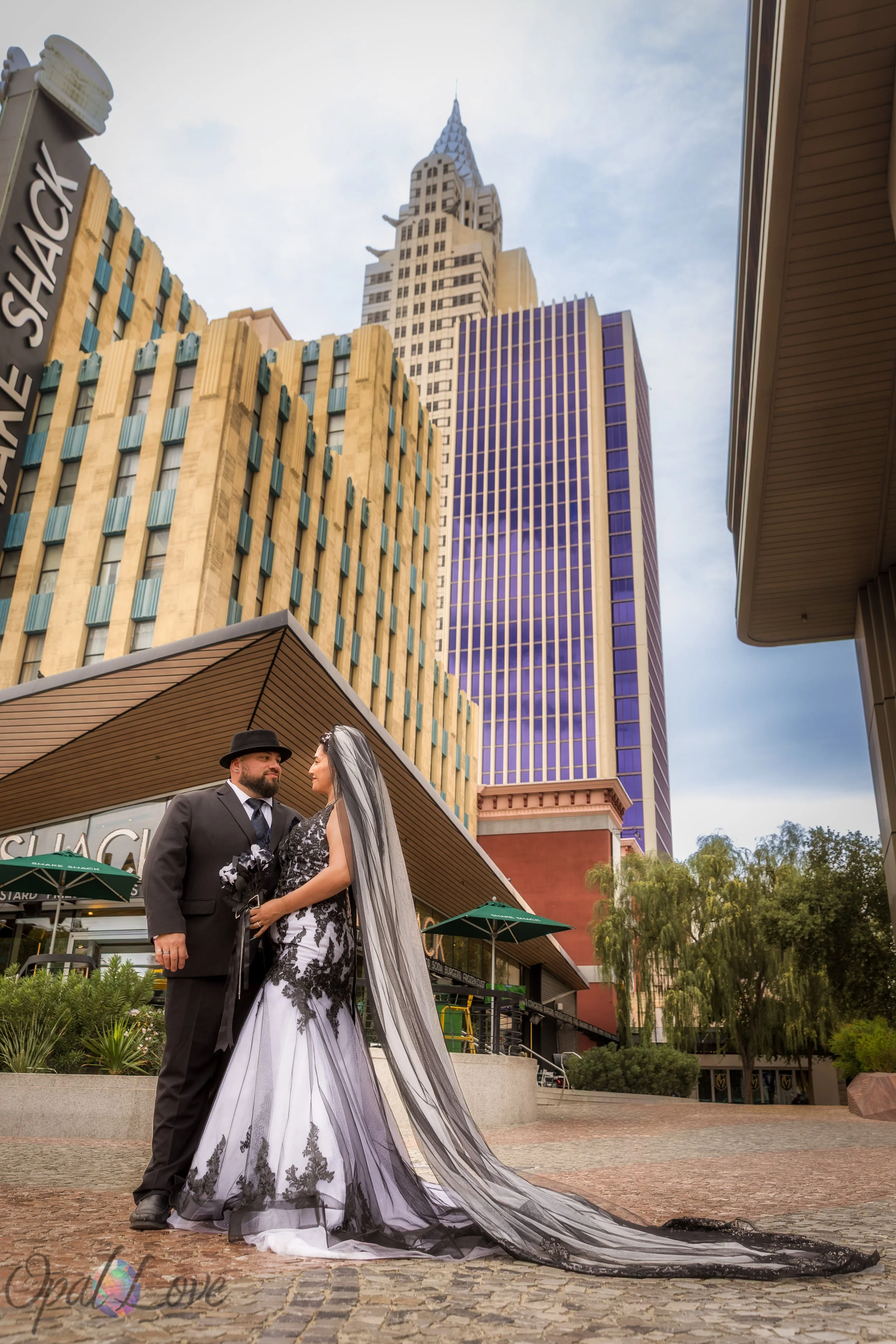 Bride’s long black veil trailing behind her while standing with groom at New York New York.