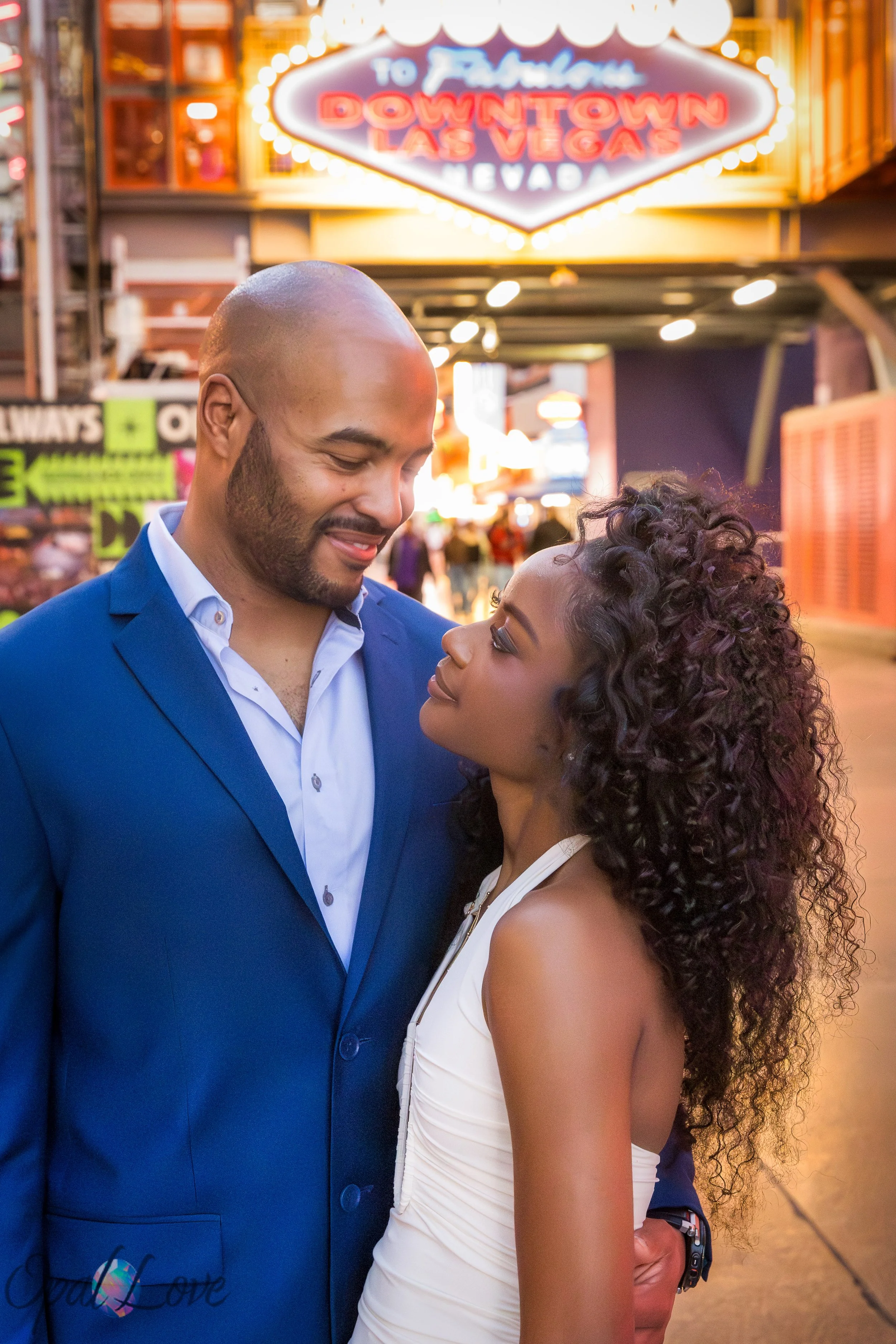 Couple standing beneath the Downtown Las Vegas entrance sign at Fremont Street.