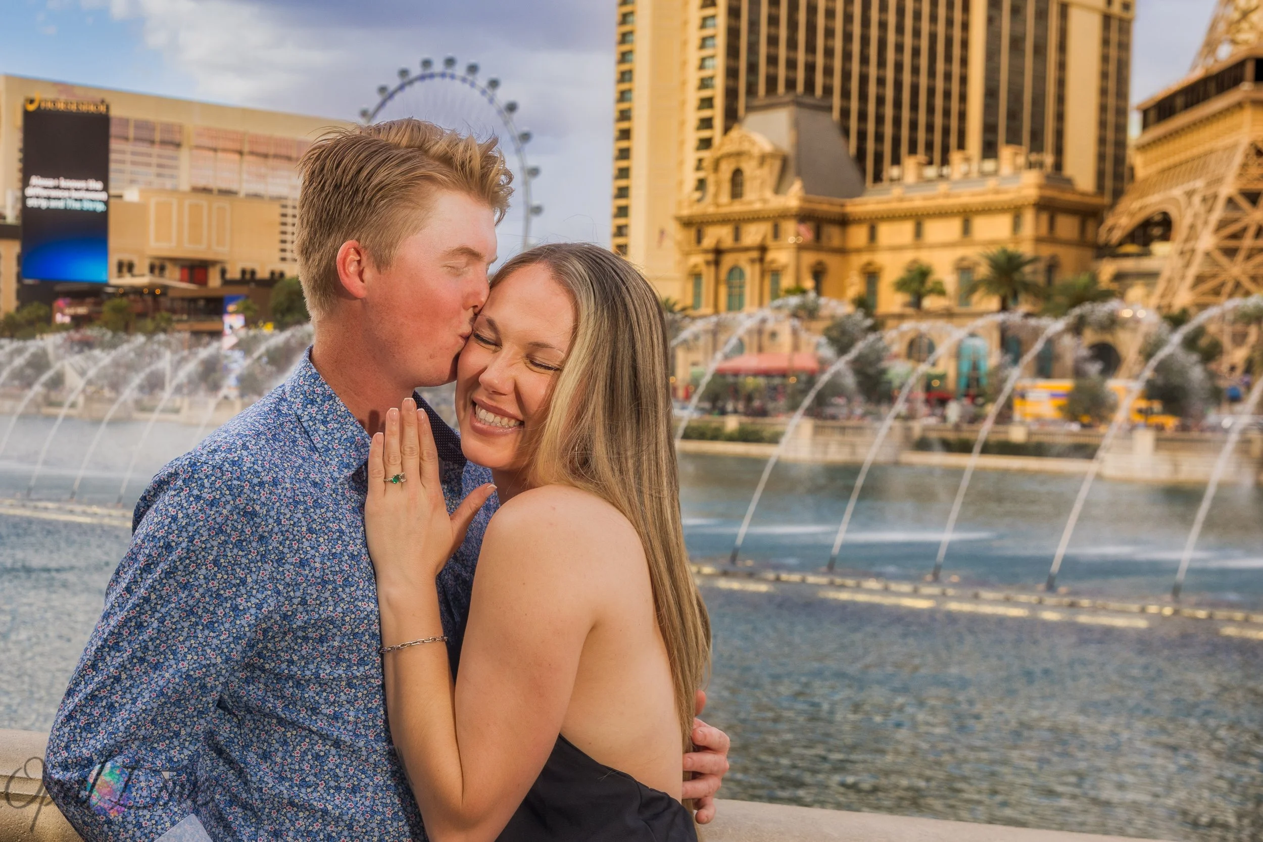 Couple smiling and celebrating engagement in front of Bellagio fountain show