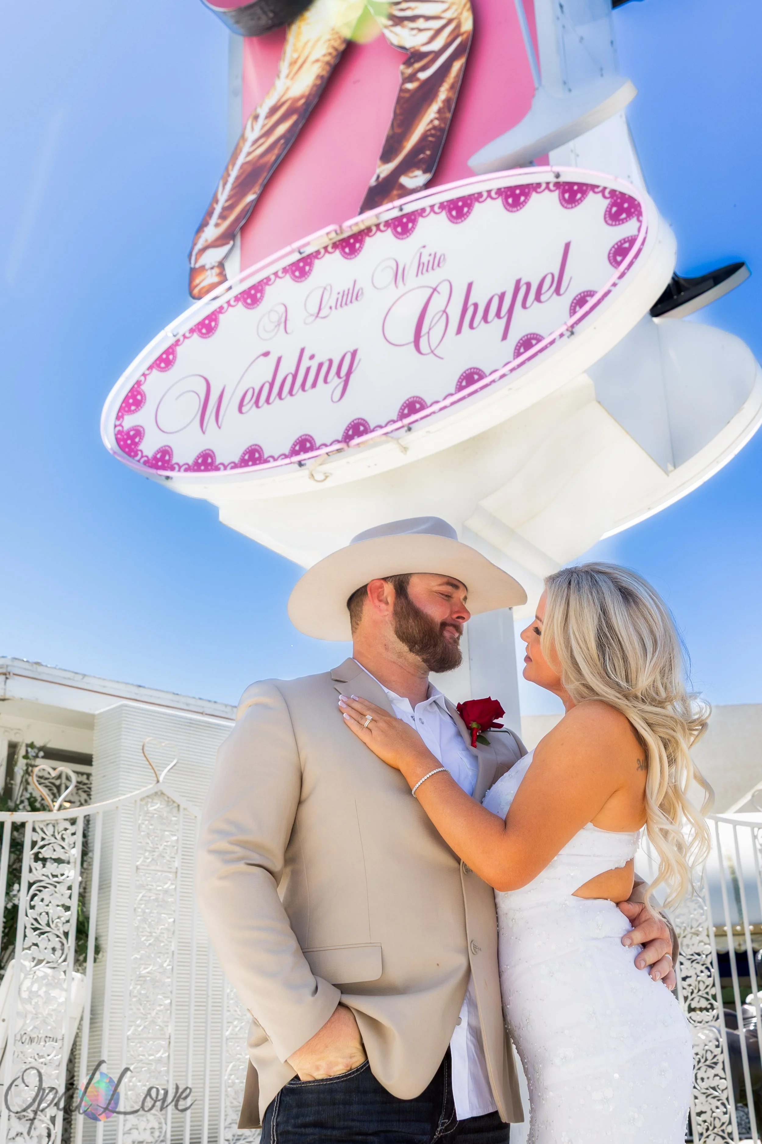 Couple embracing beneath the A Little White Wedding Chapel sign during their Las Vegas elopement photography session