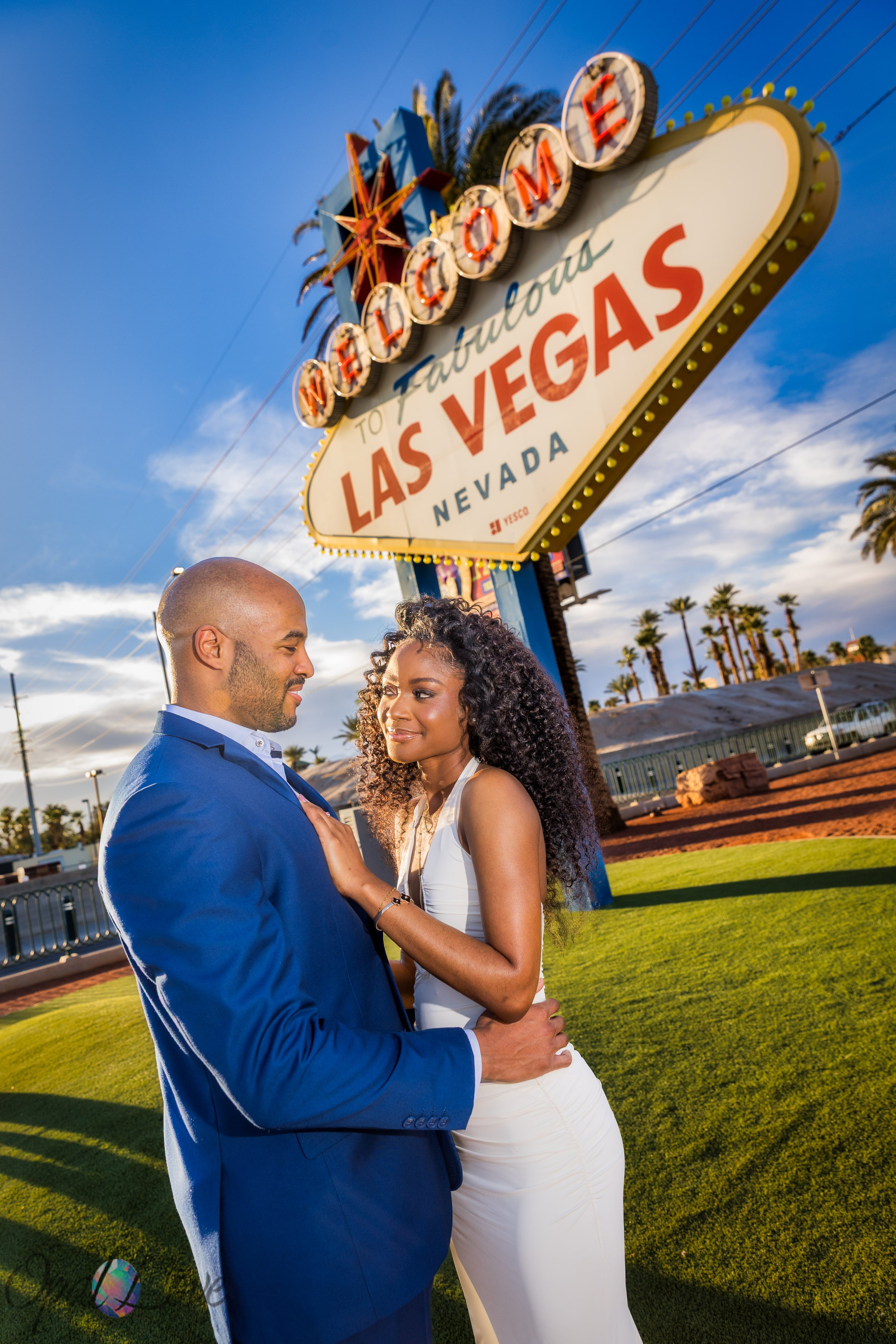 Couple embracing at the Welcome to Fabulous Las Vegas sign during a birthday photo session in Las Vegas.