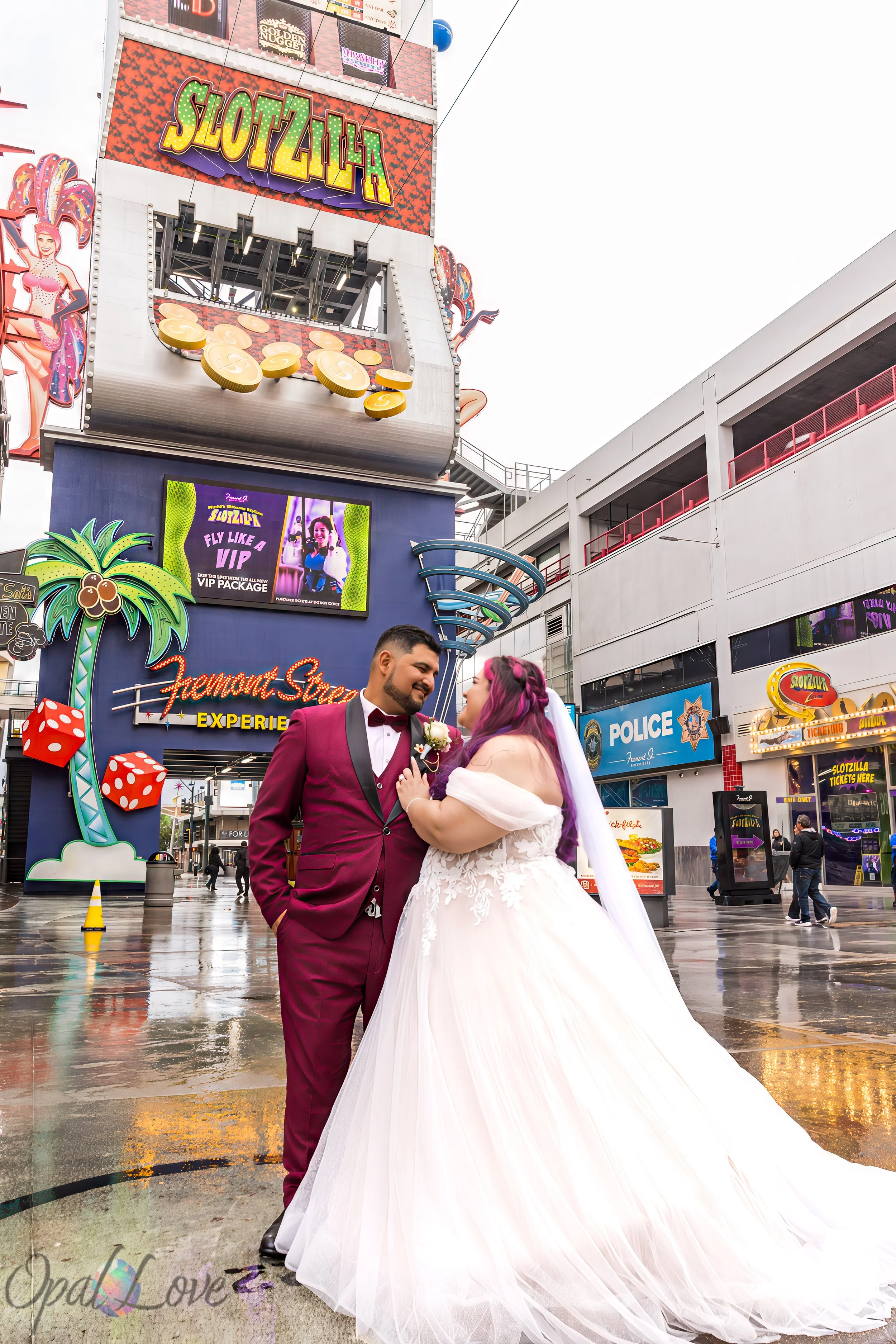 Couple posing in wedding attire in front of SlotZilla on Fremont Street.