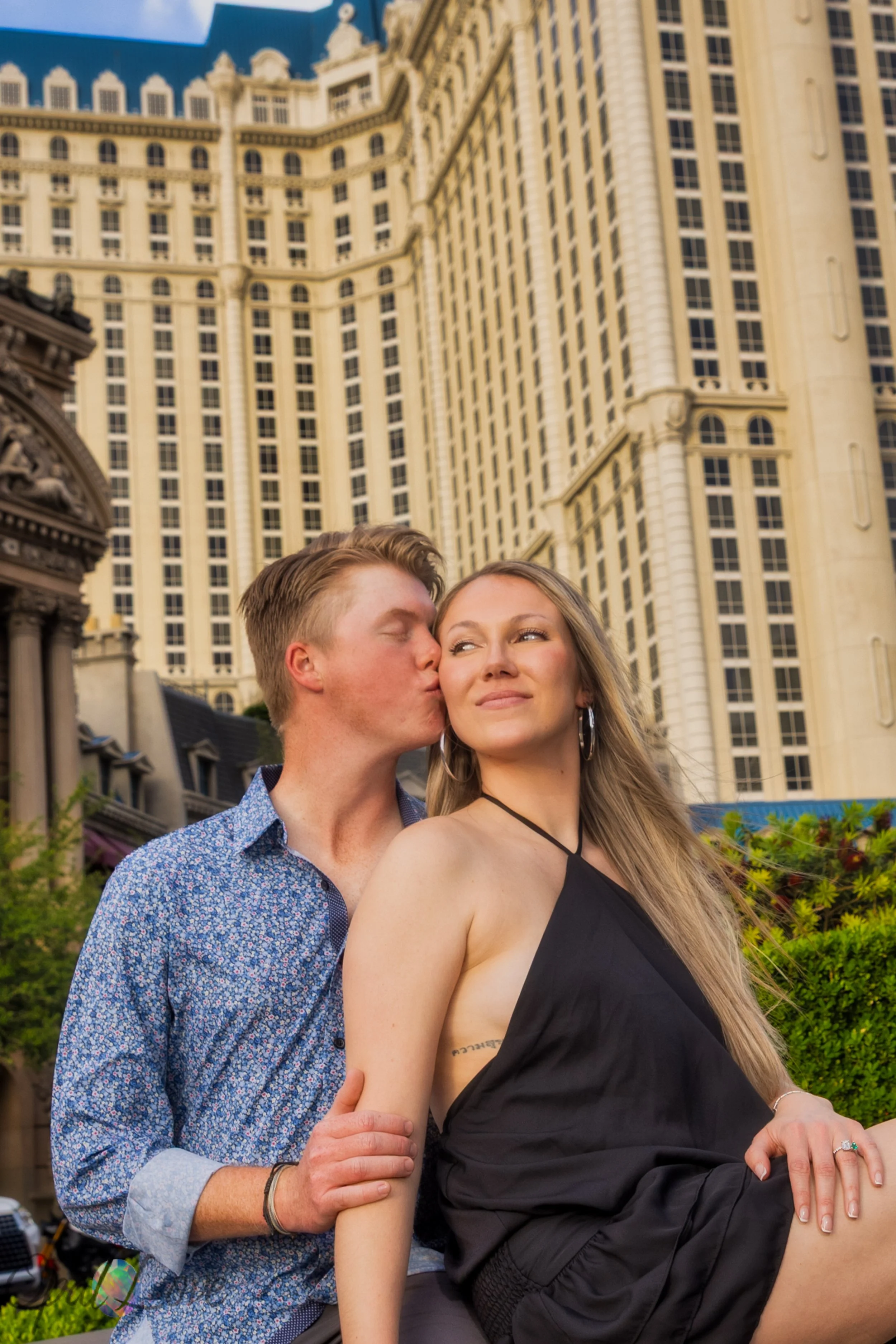 Couple standing under Paris Las Vegas archway with Eiffel Tower nearby