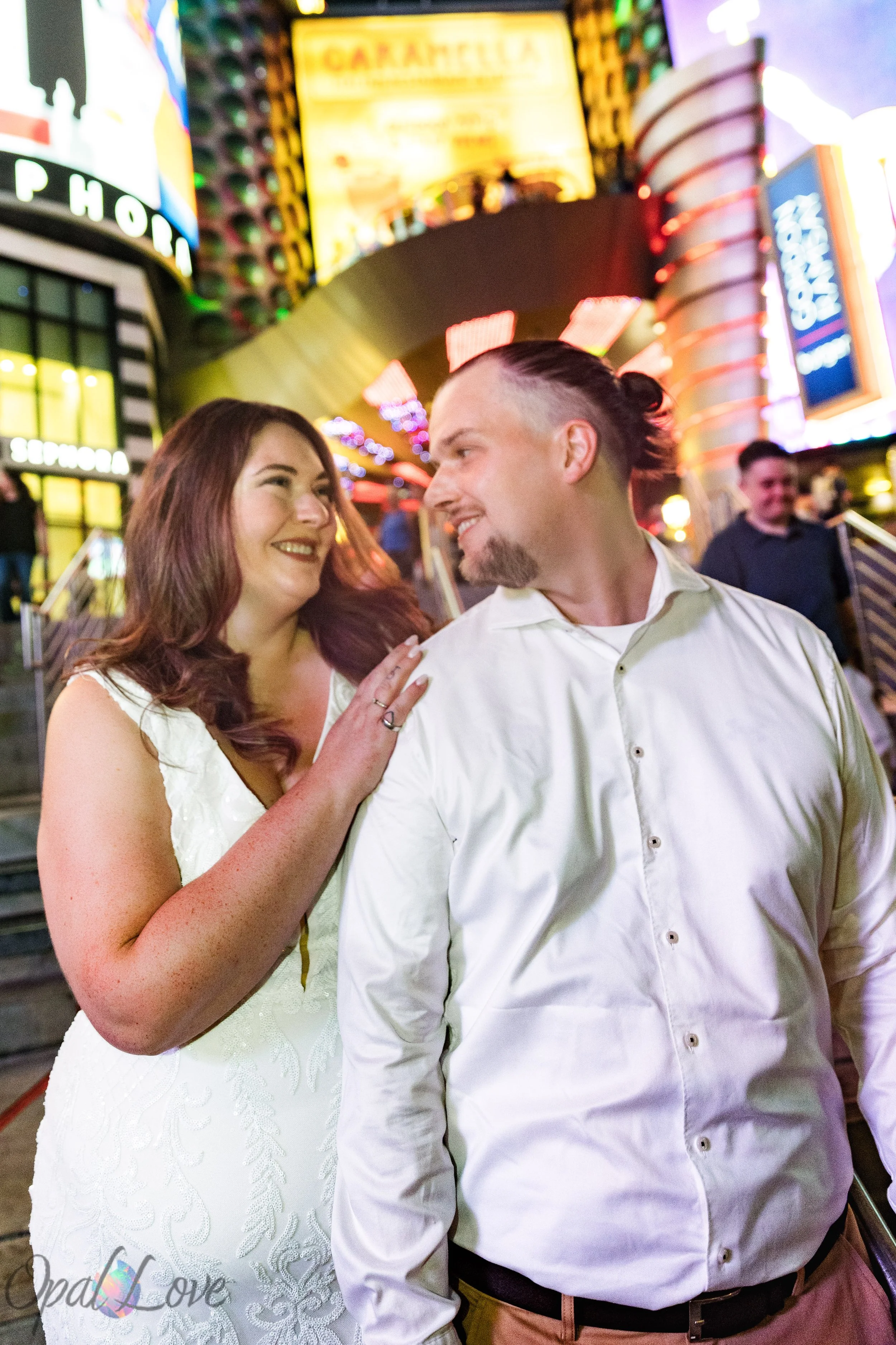 Dustin and Jacqueline laughing together during their nighttime Las Vegas vow renewal photo session near Planet Hollywood.