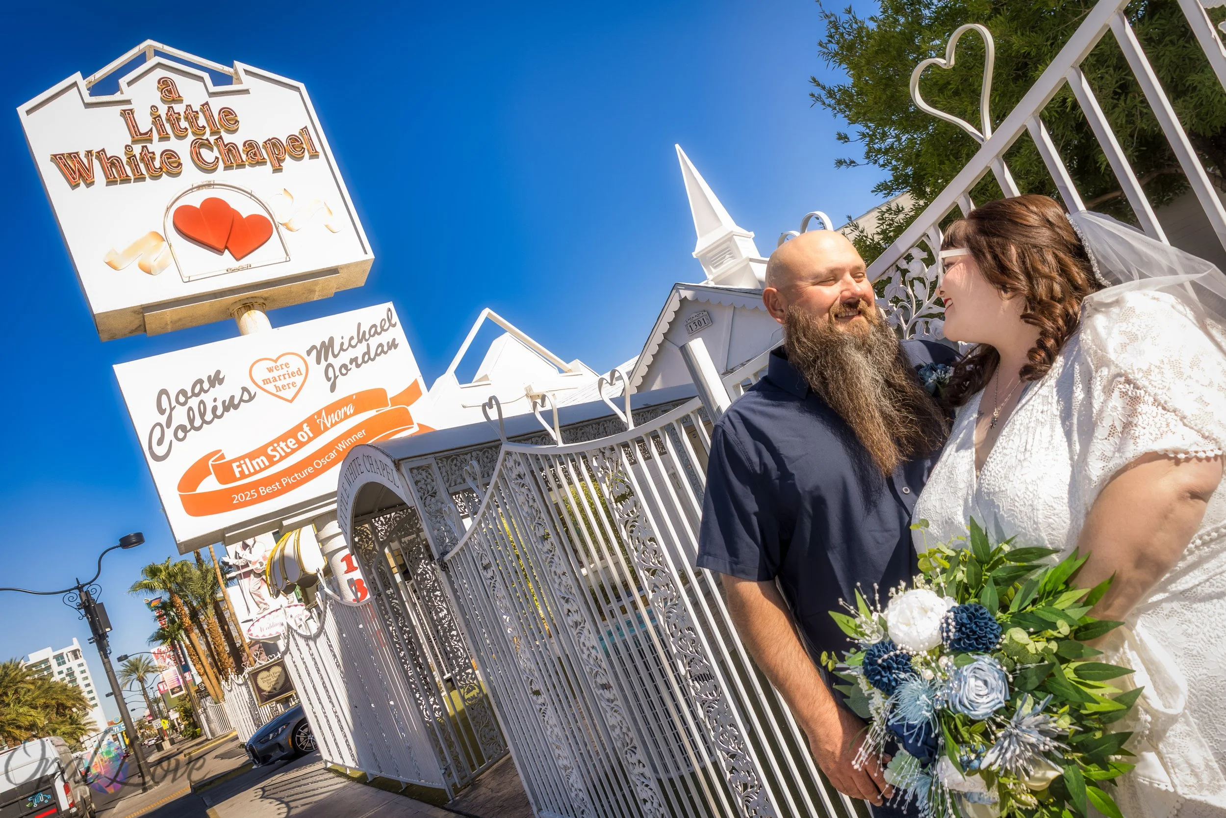 Couple smiling together near the main gate of A Little White Chapel.