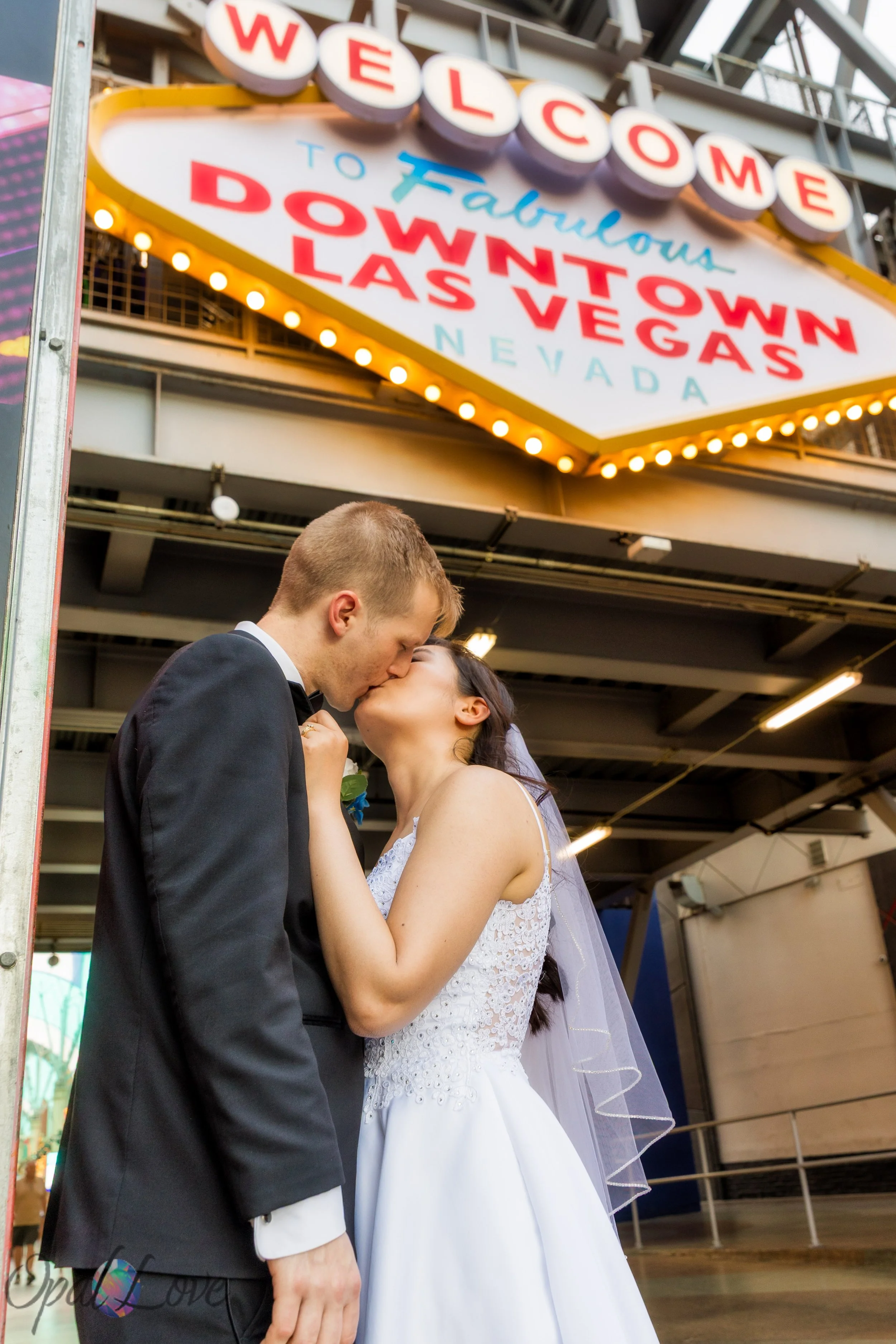 Couple sharing a kiss under the Downtown Las Vegas sign during their Las Vegas elopement photo tour.
