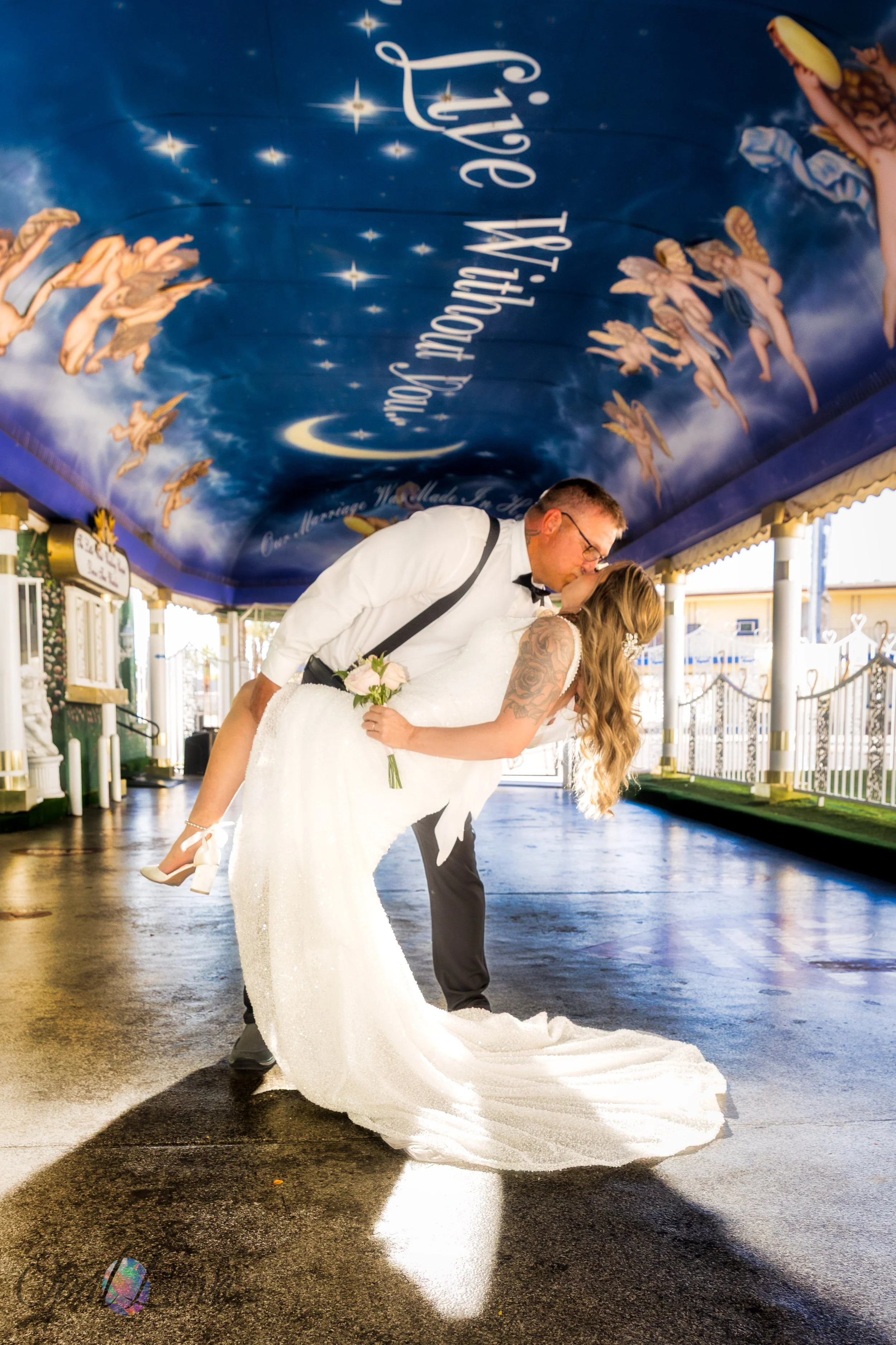 Groom dipping bride for a kiss under Tunnel of Love ceiling at Little White Chapel.