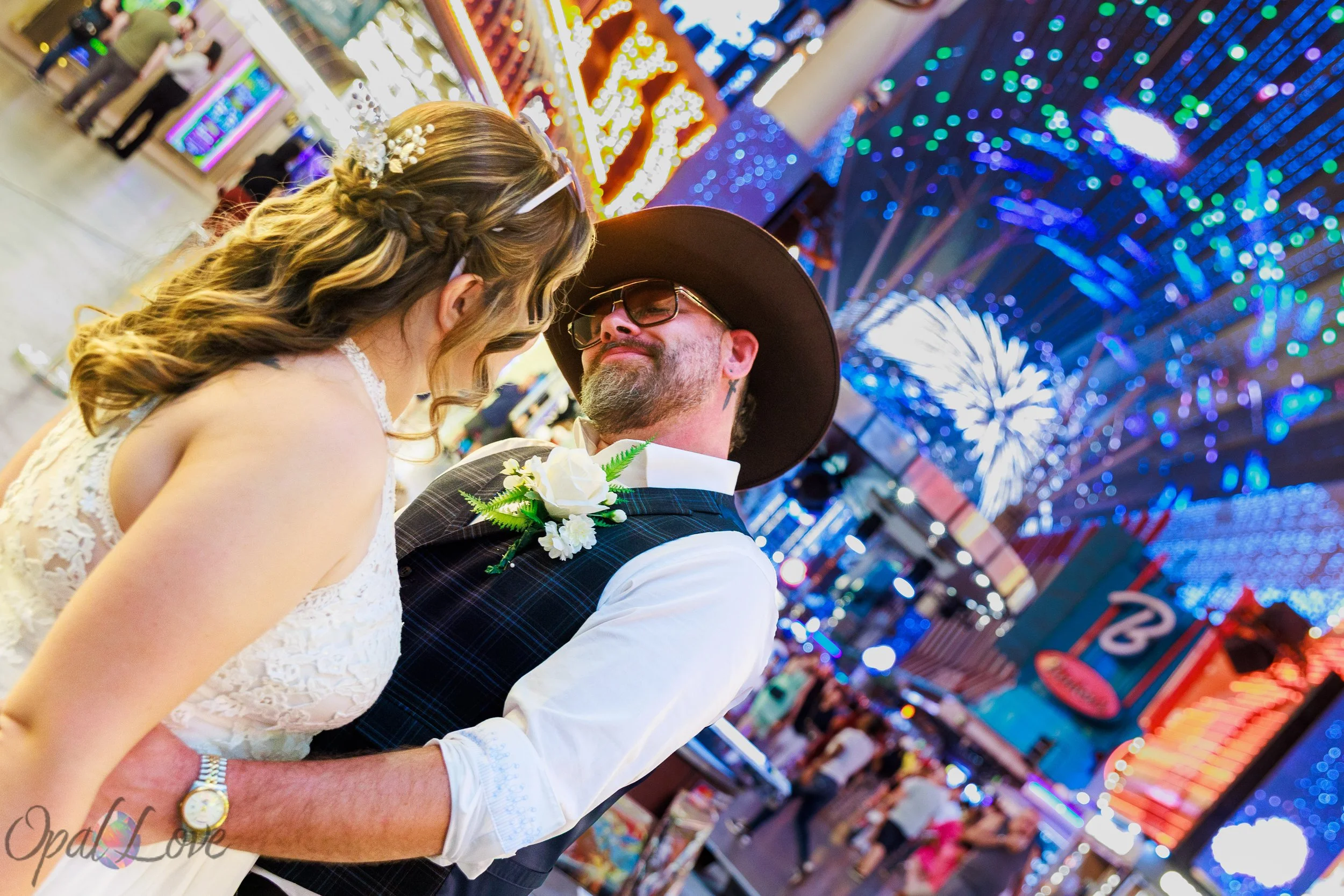 Couple embracing beneath the colorful lights of the Fremont Street canopy.
