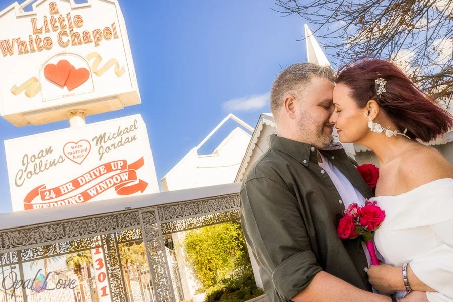 Newlywed couple embracing outside the Little White Wedding Chapel in Las Vegas.