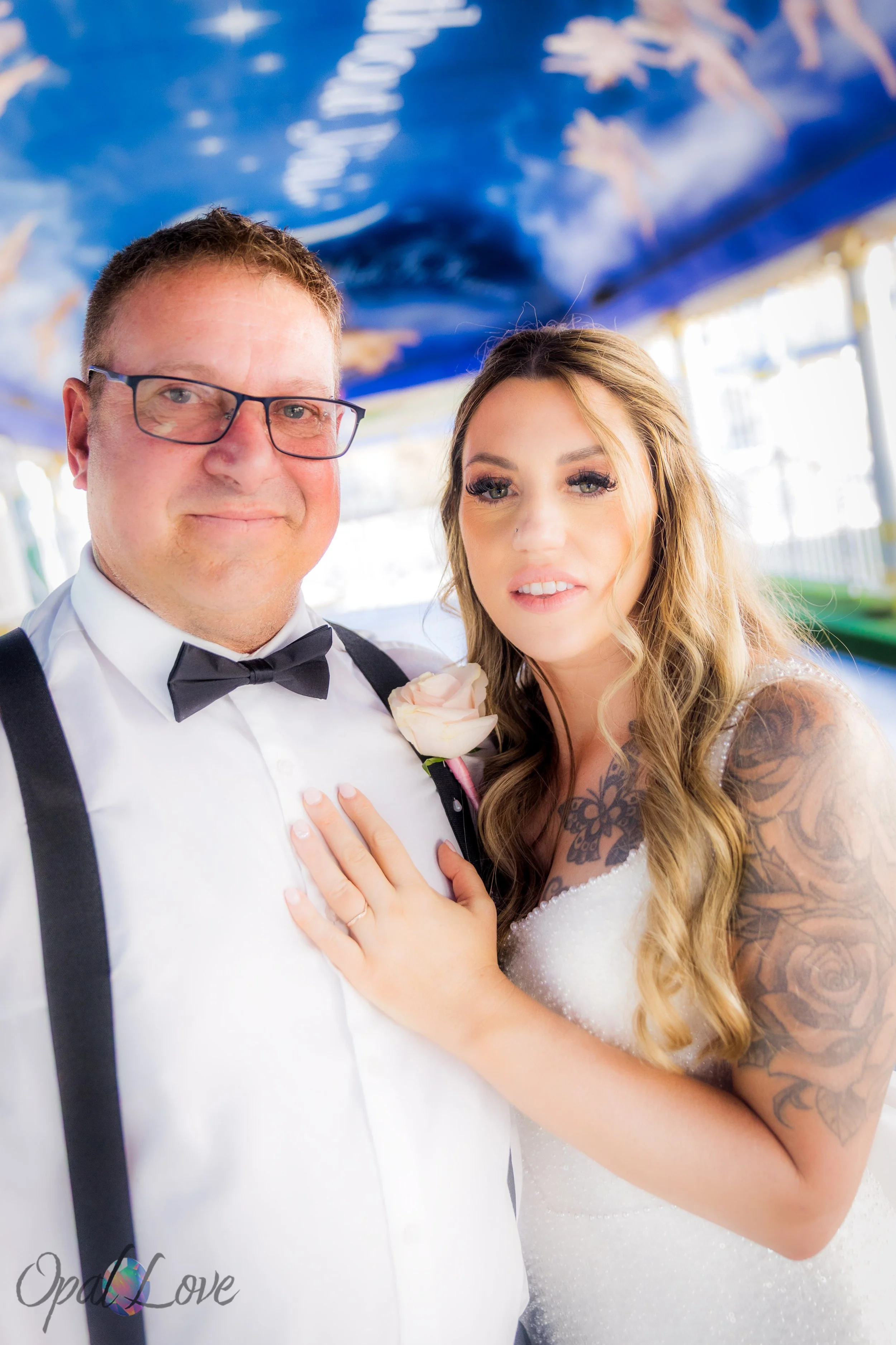 Bride showing ring with groom smiling beside her under star-painted canopy.
