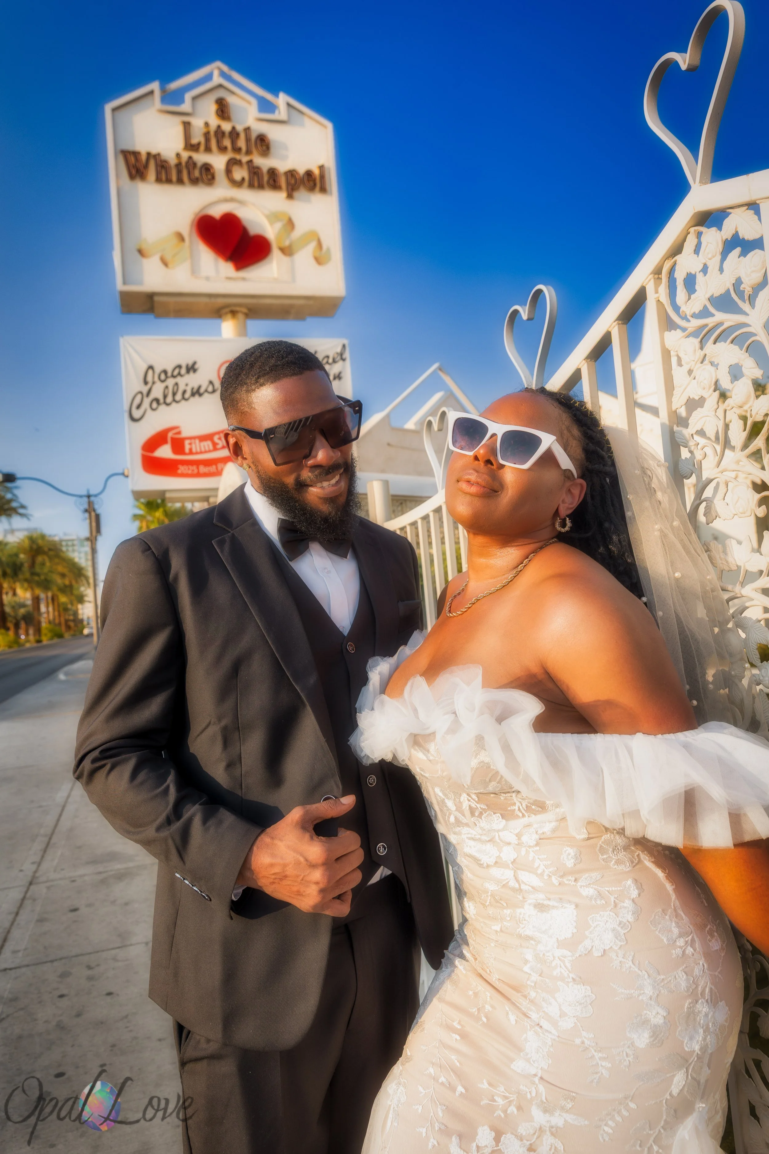 Stylish newlyweds wearing sunglasses outside the Little White Chapel in Las Vegas.