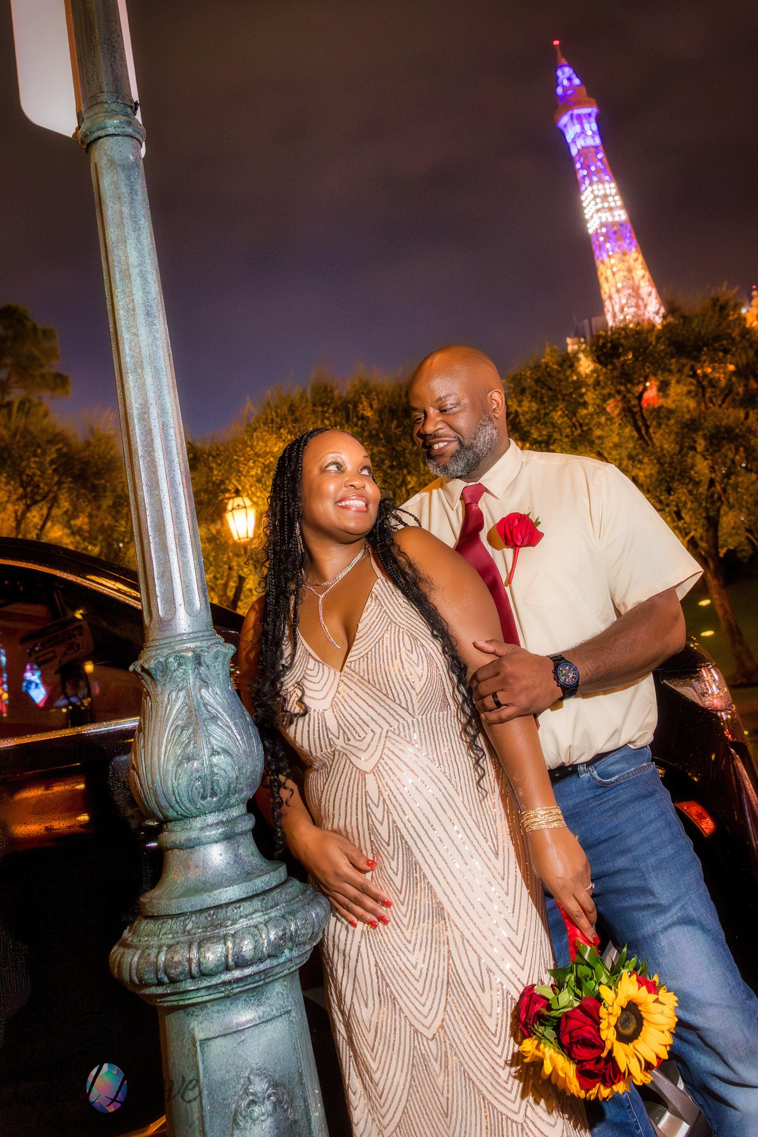 Couple sharing a moment under a streetlamp near Paris Las Vegas with Eiffel Tower glowing