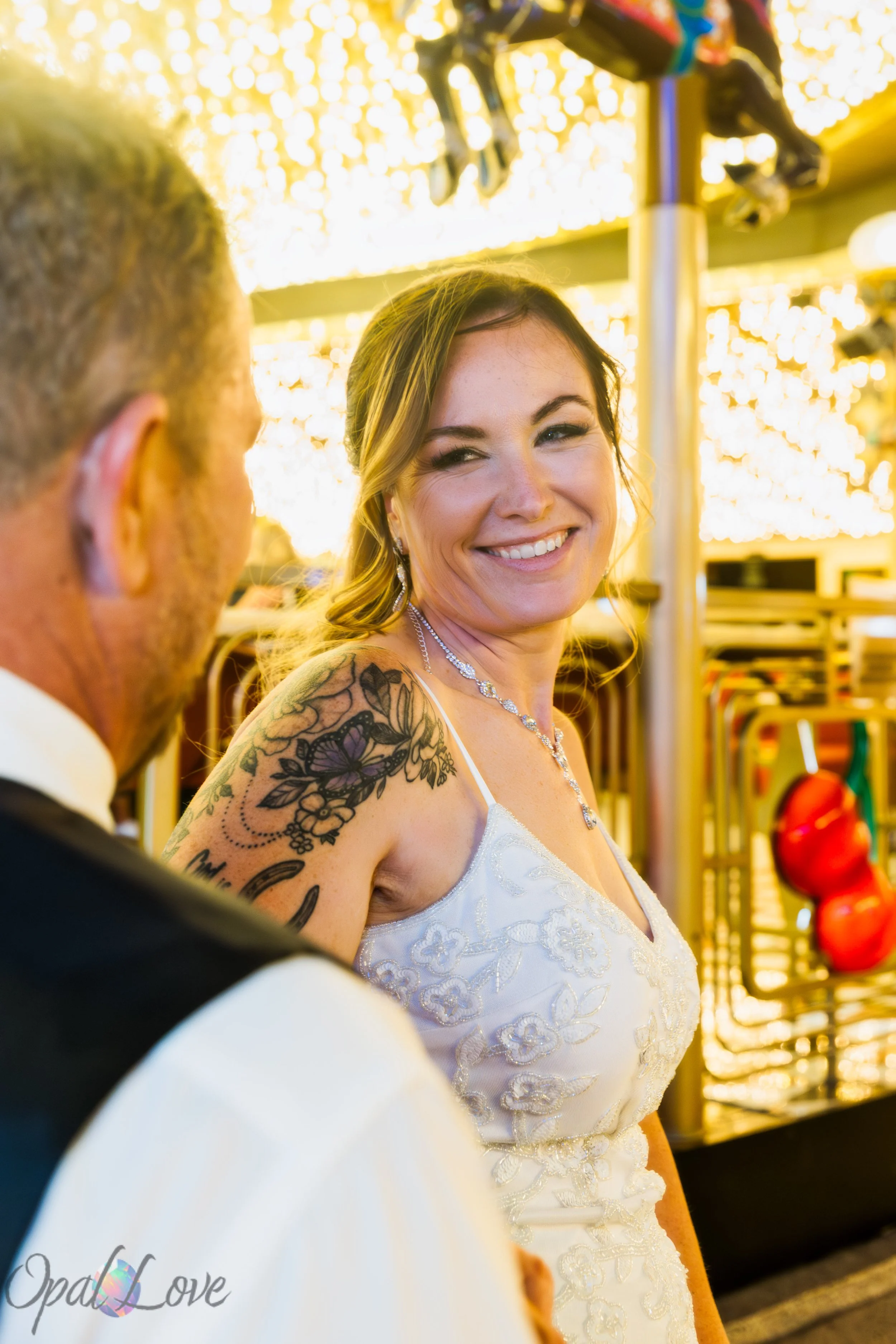Bride smiling beneath the glowing lights of Fremont Street during a Las Vegas wedding photography session.