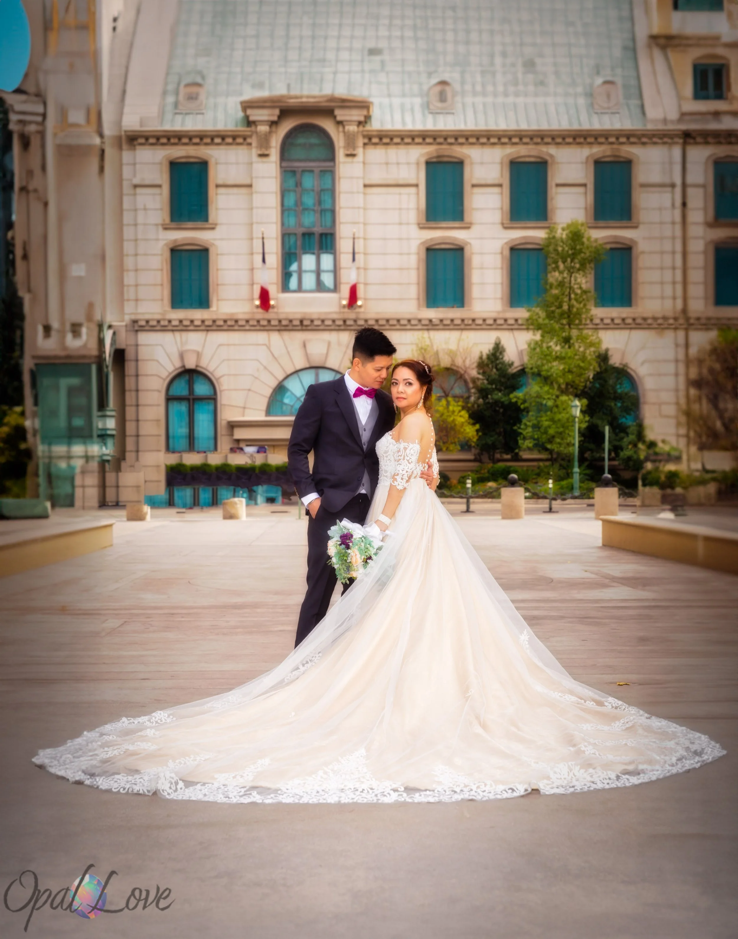 Newlywed couple posing together in front of elegant Las Vegas architecture.
