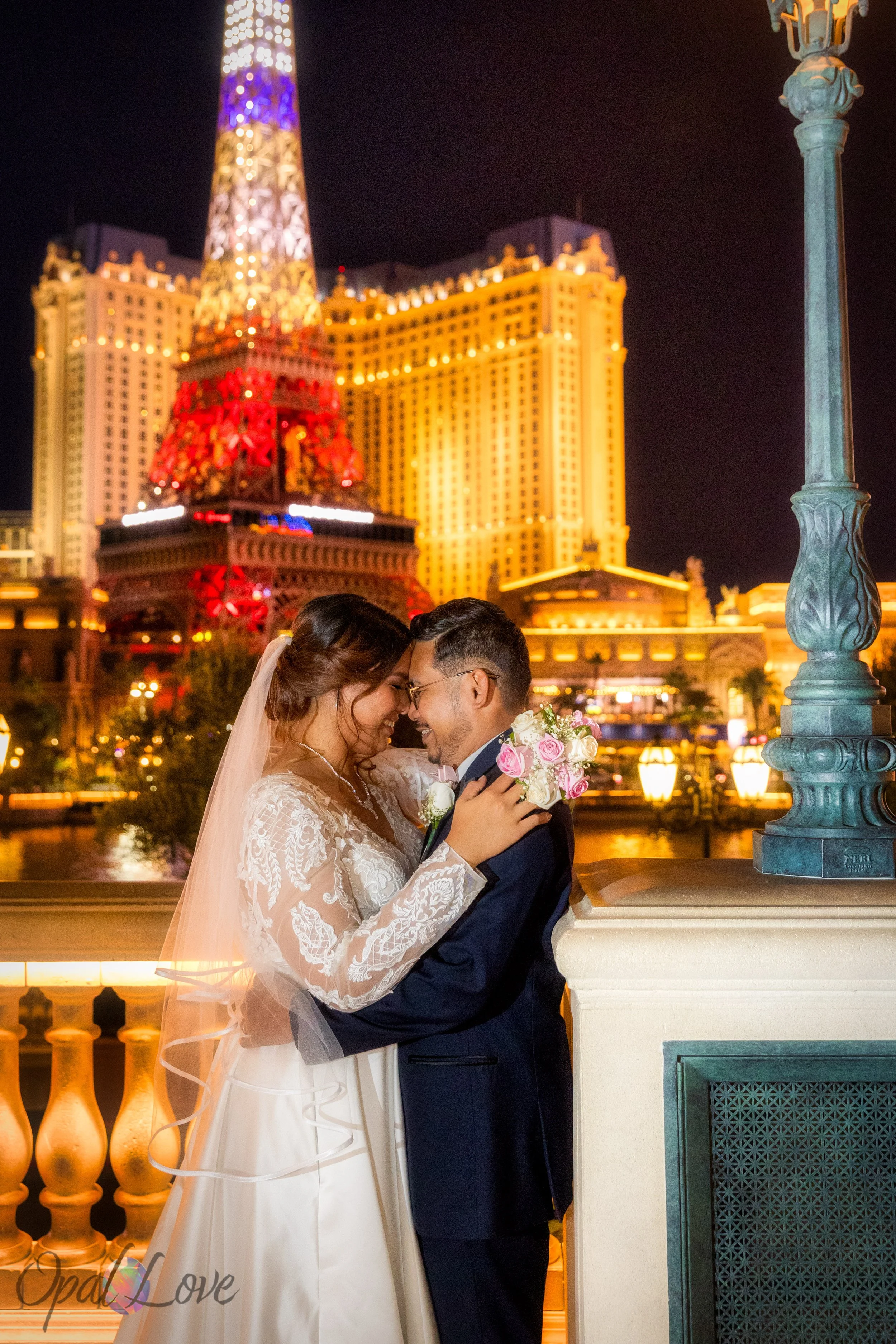 Bride and groom embracing with Paris Las Vegas Eiffel Tower lit up behind them
