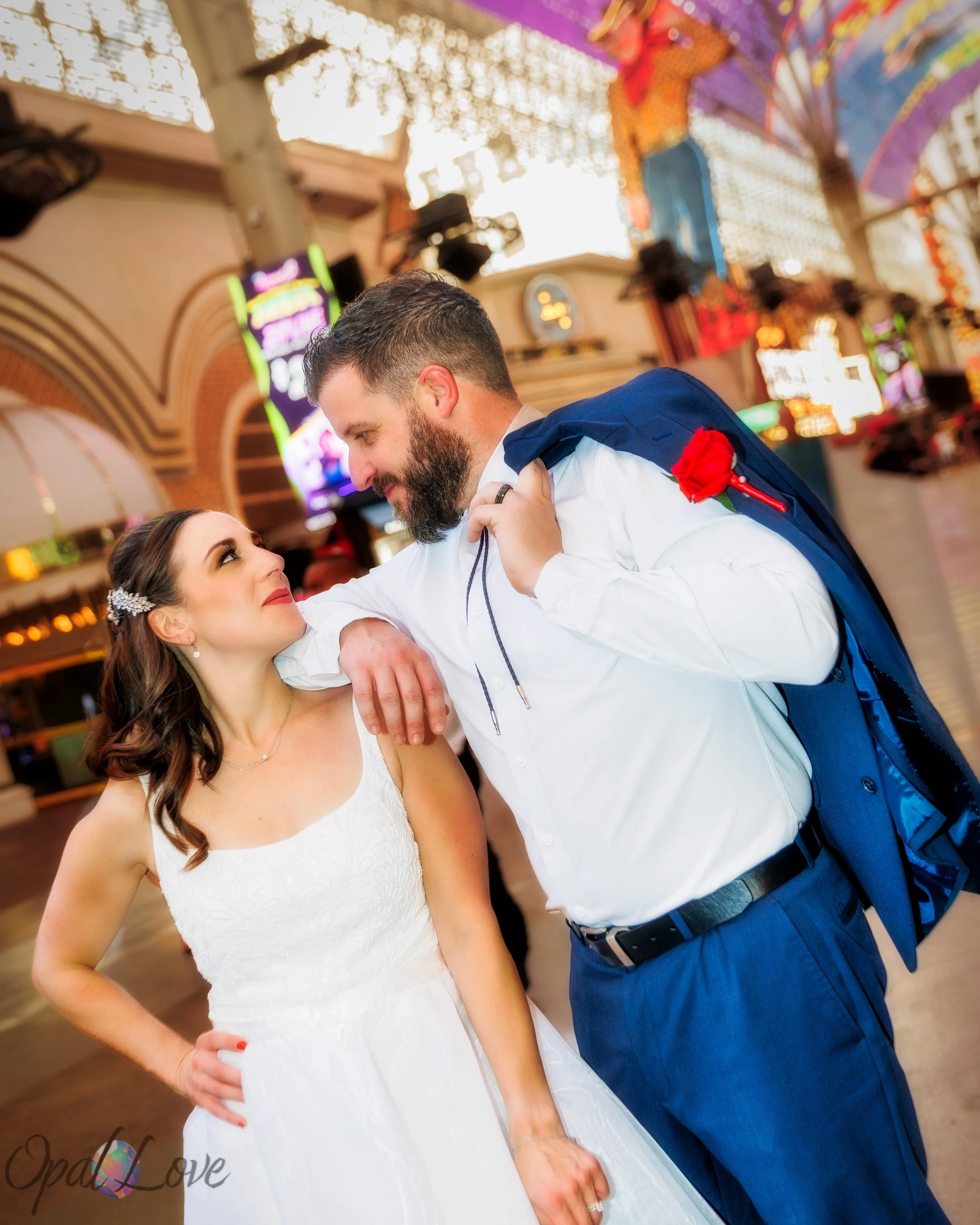 Newlyweds pose beneath the colorful lights of the Fremont Street Experience in downtown Las Vegas.