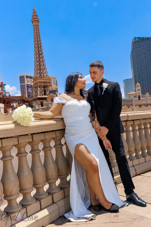 Newlywed couple at Caesars Palace with the Eiffel Tower at Paris Las Vegas in the background.