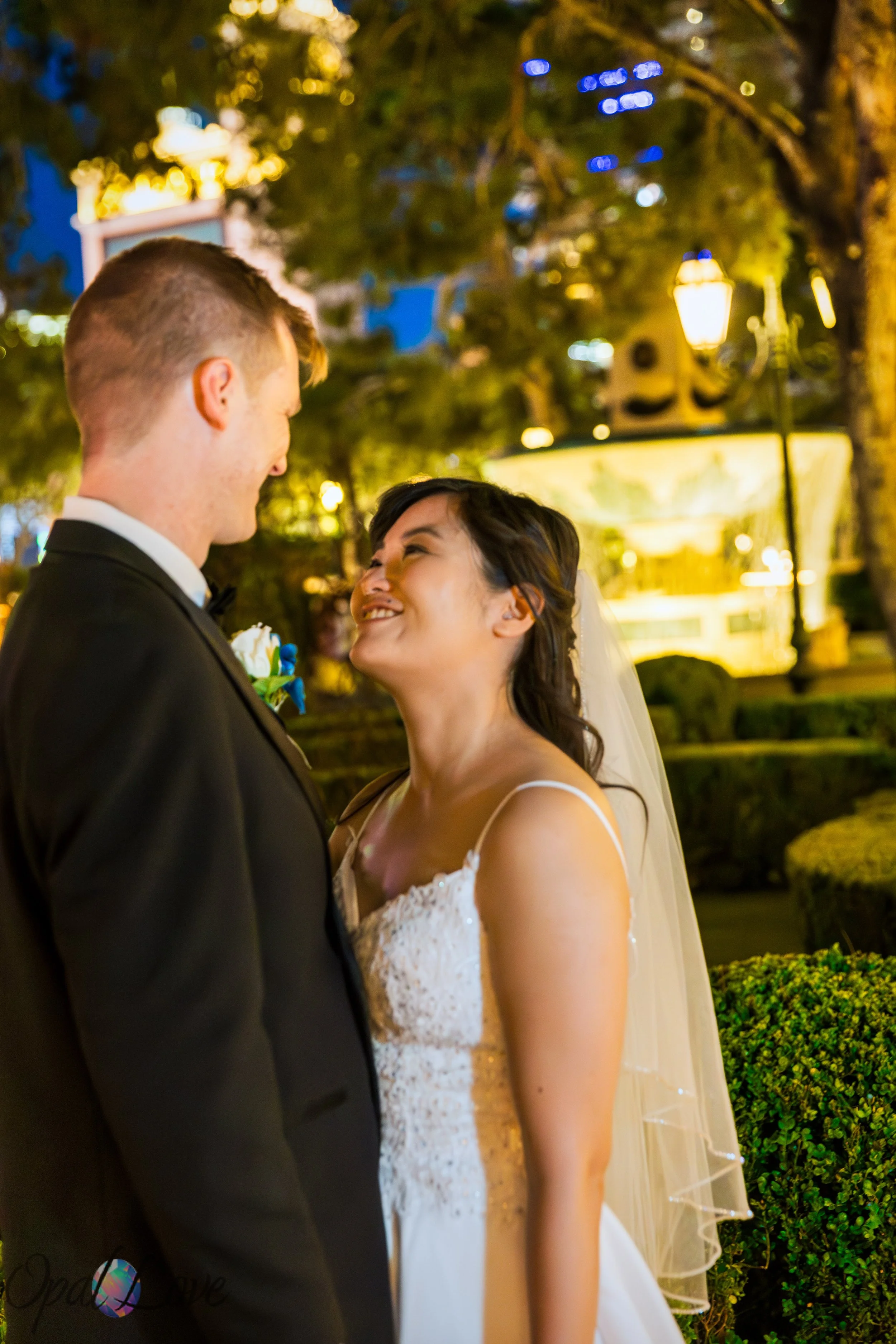 Bride and groom smiling together during nighttime wedding portraits at the Bellagio in Las Vegas.