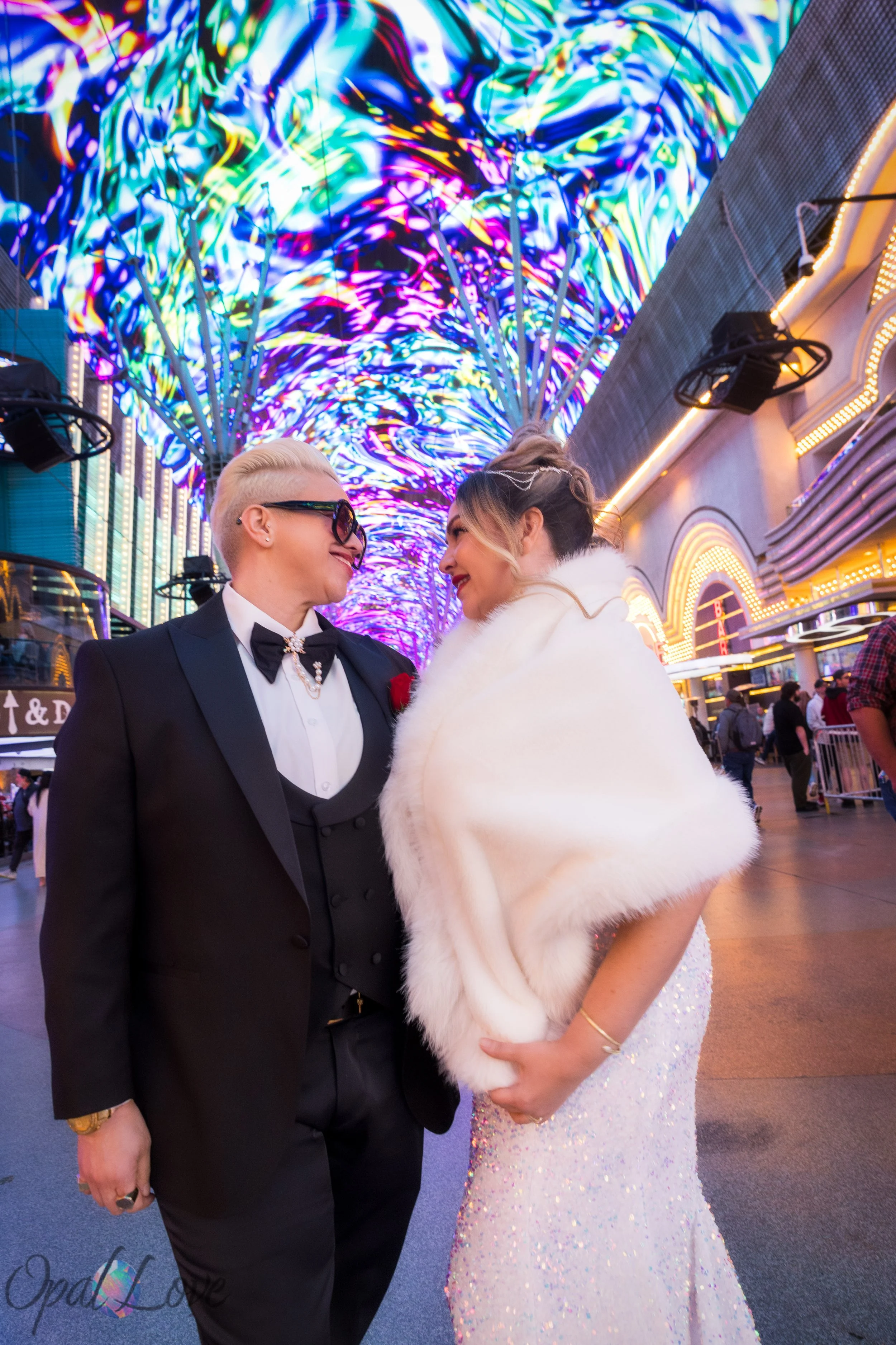 Couple sharing a romantic moment beneath the vibrant lights of the Fremont Street Experience canopy.