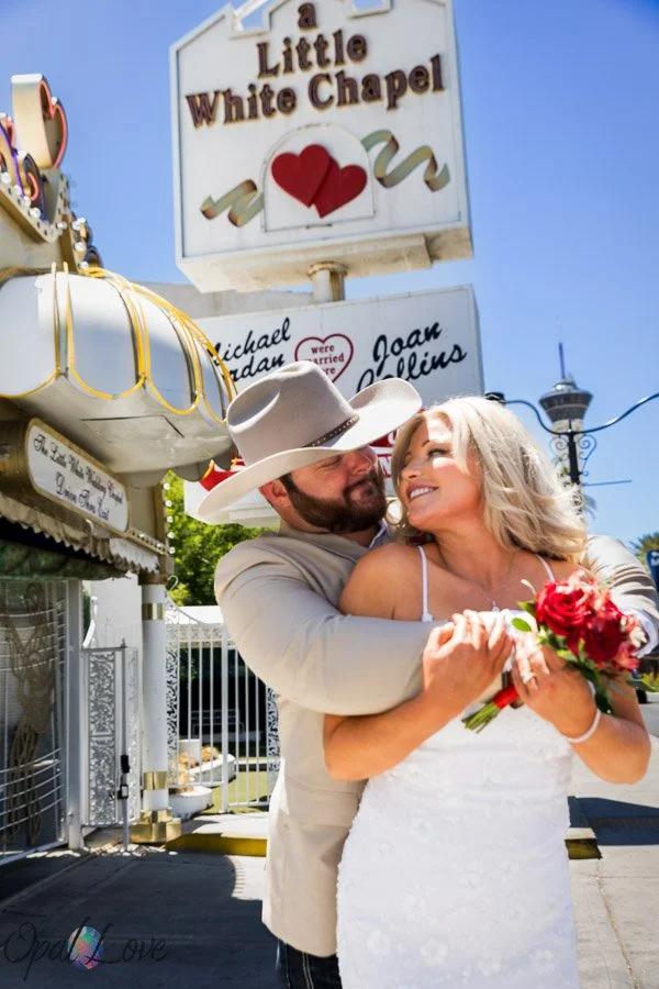 Newlywed couple embracing outside the Little White Wedding Chapel in Las Vegas.