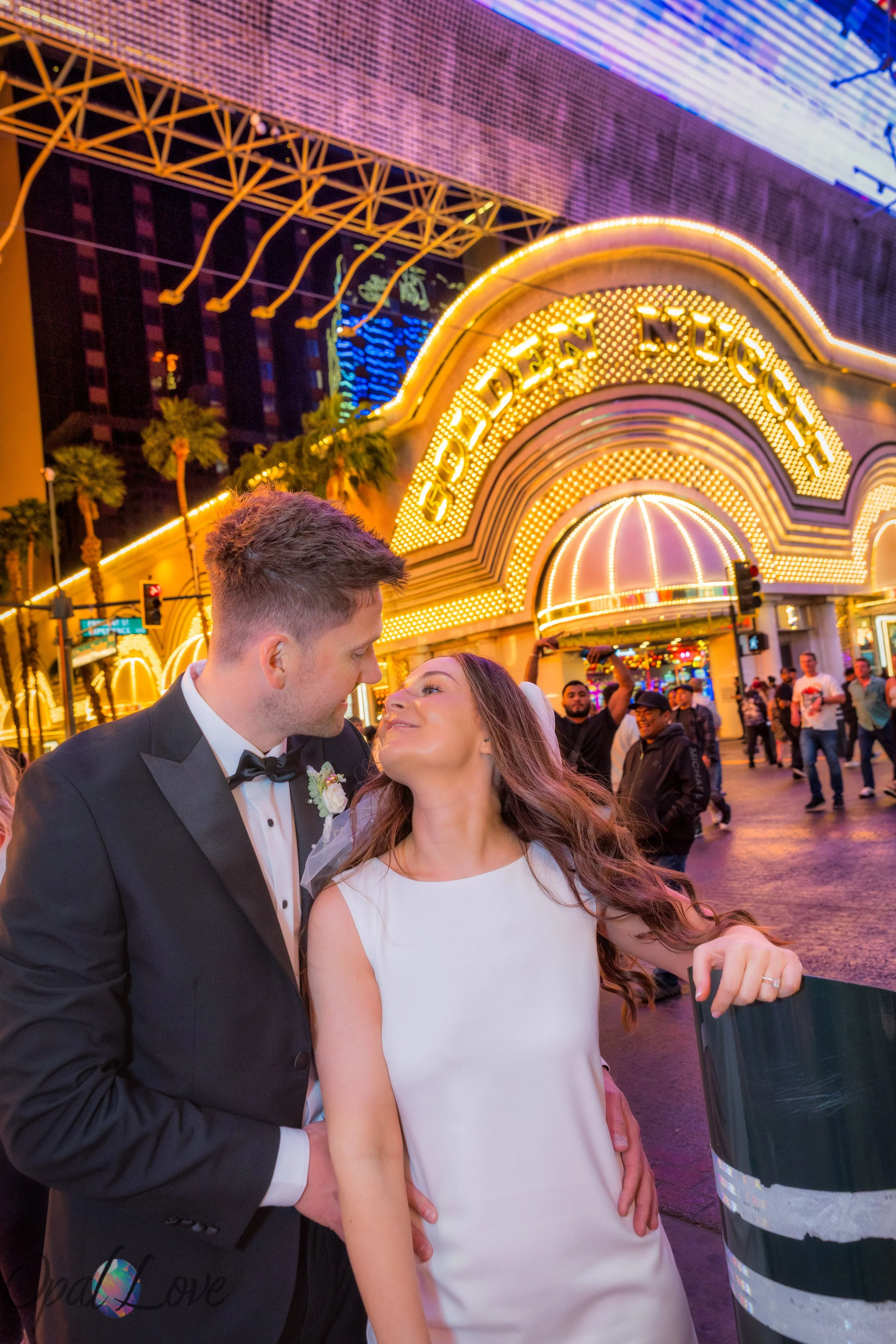 Bride and groom walking together near Golden Nugget sign on Fremont Street