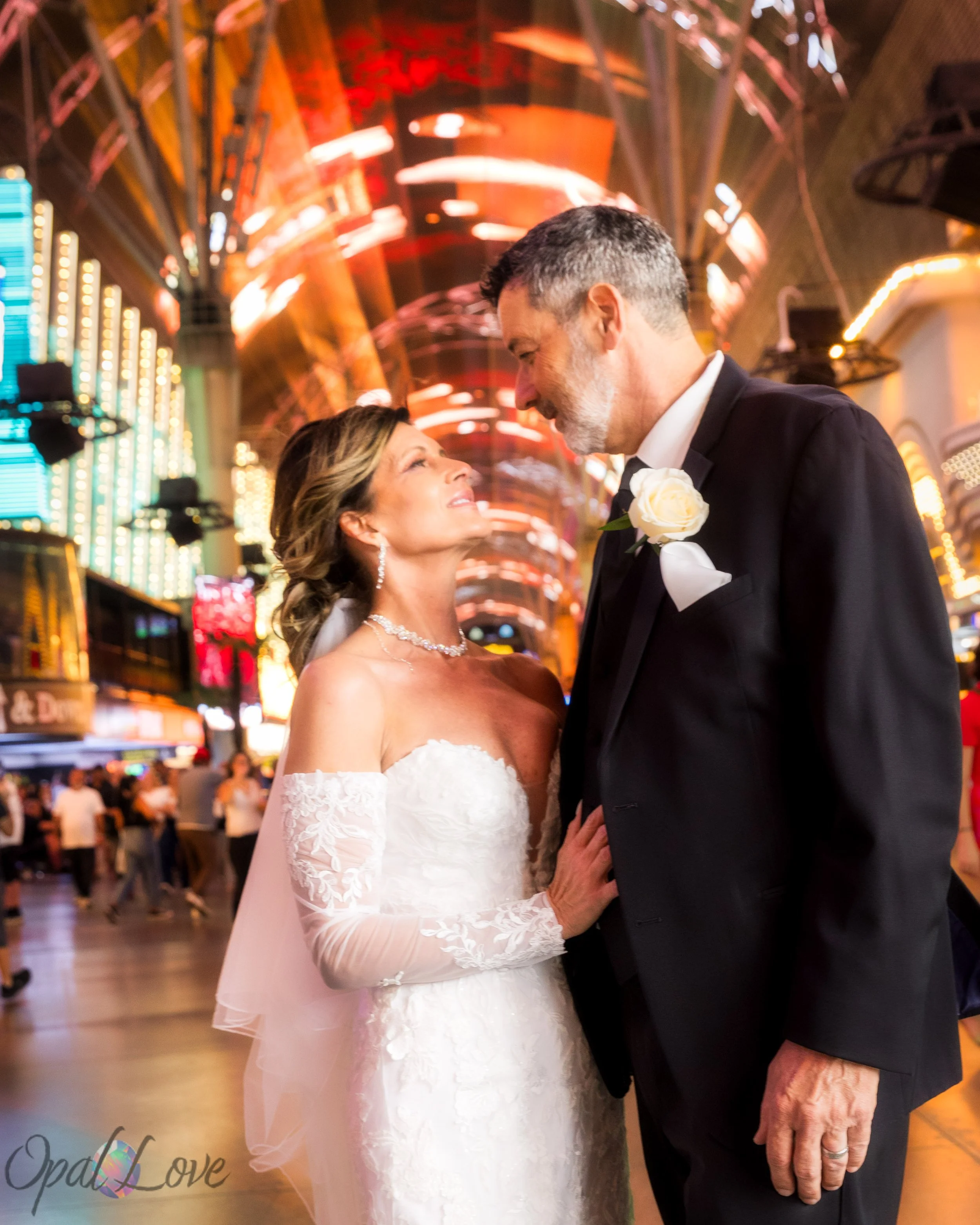Newlywed couple beneath the colorful Fremont Street Experience canopy in Downtown Las Vegas.