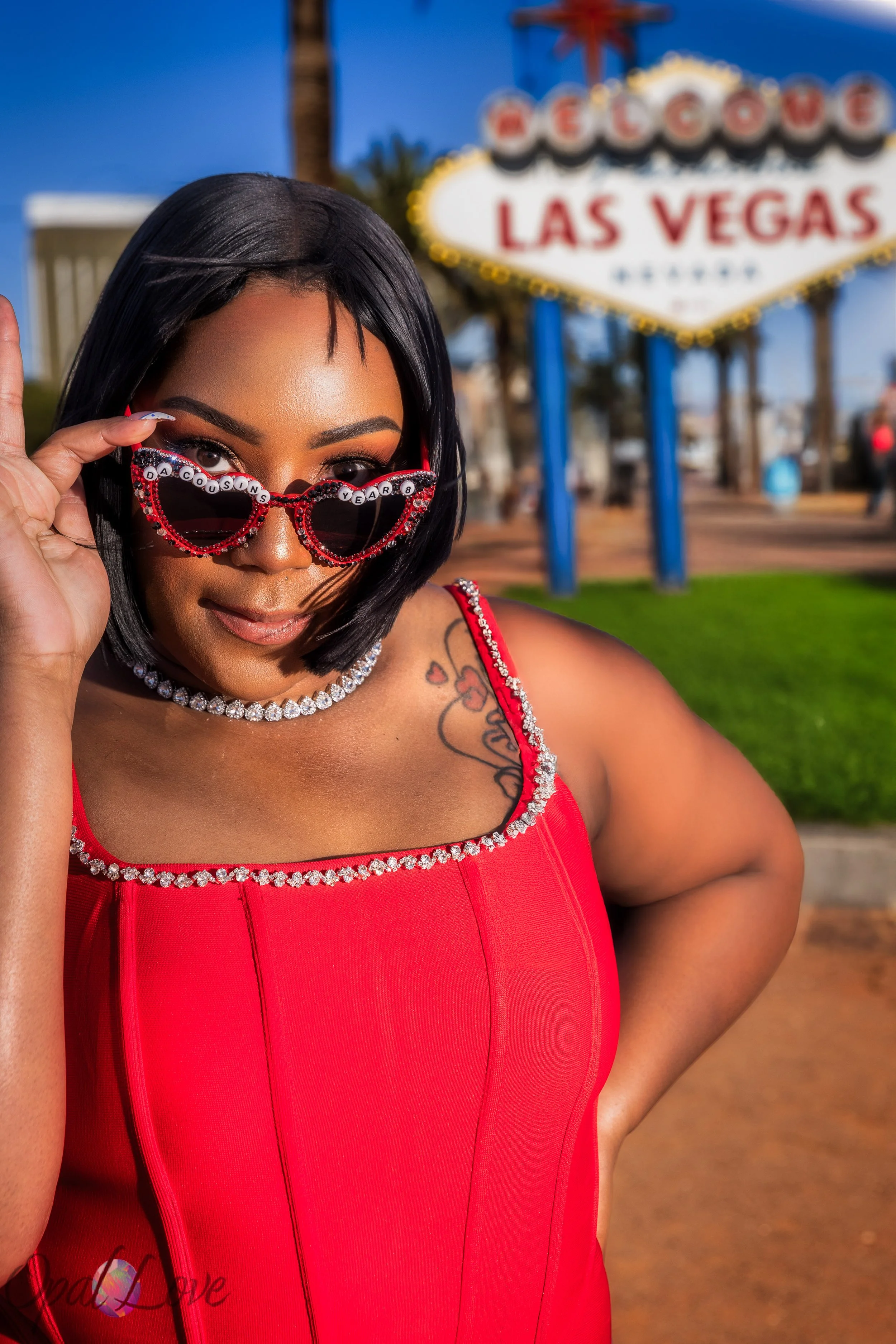 Close portrait of woman wearing heart shaped sunglasses during an anniversary photo session at the Las Vegas sign.